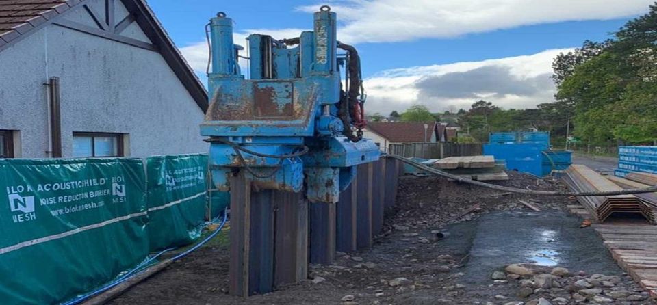 Silent press-in piling machine installing steel sheet piles next to existing buildings
