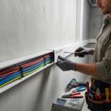 A Person installing bulette pvc trunking