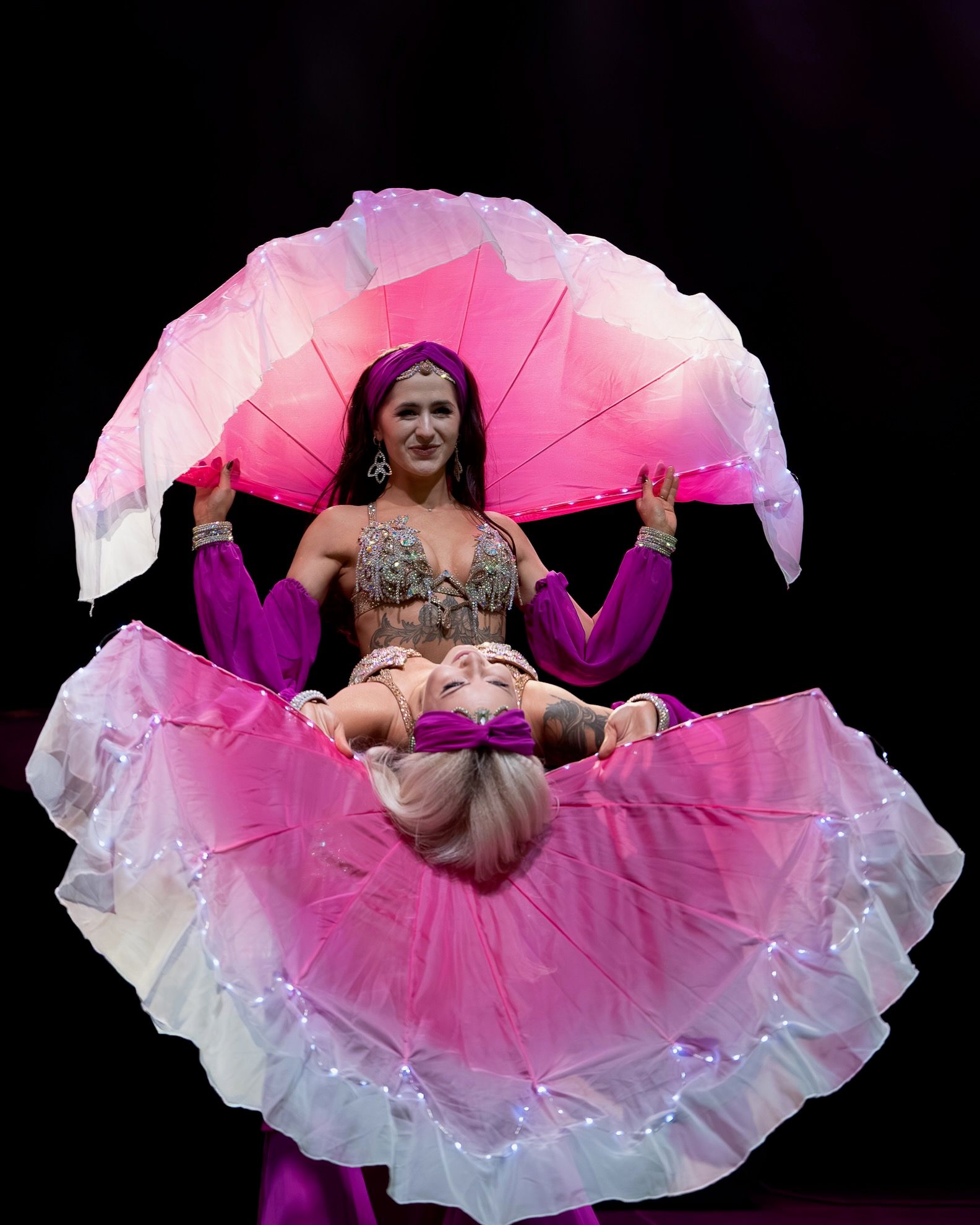 Pokaz tańca brzucha Wahatan ze świecącymi różowymi woalami LED na scenie