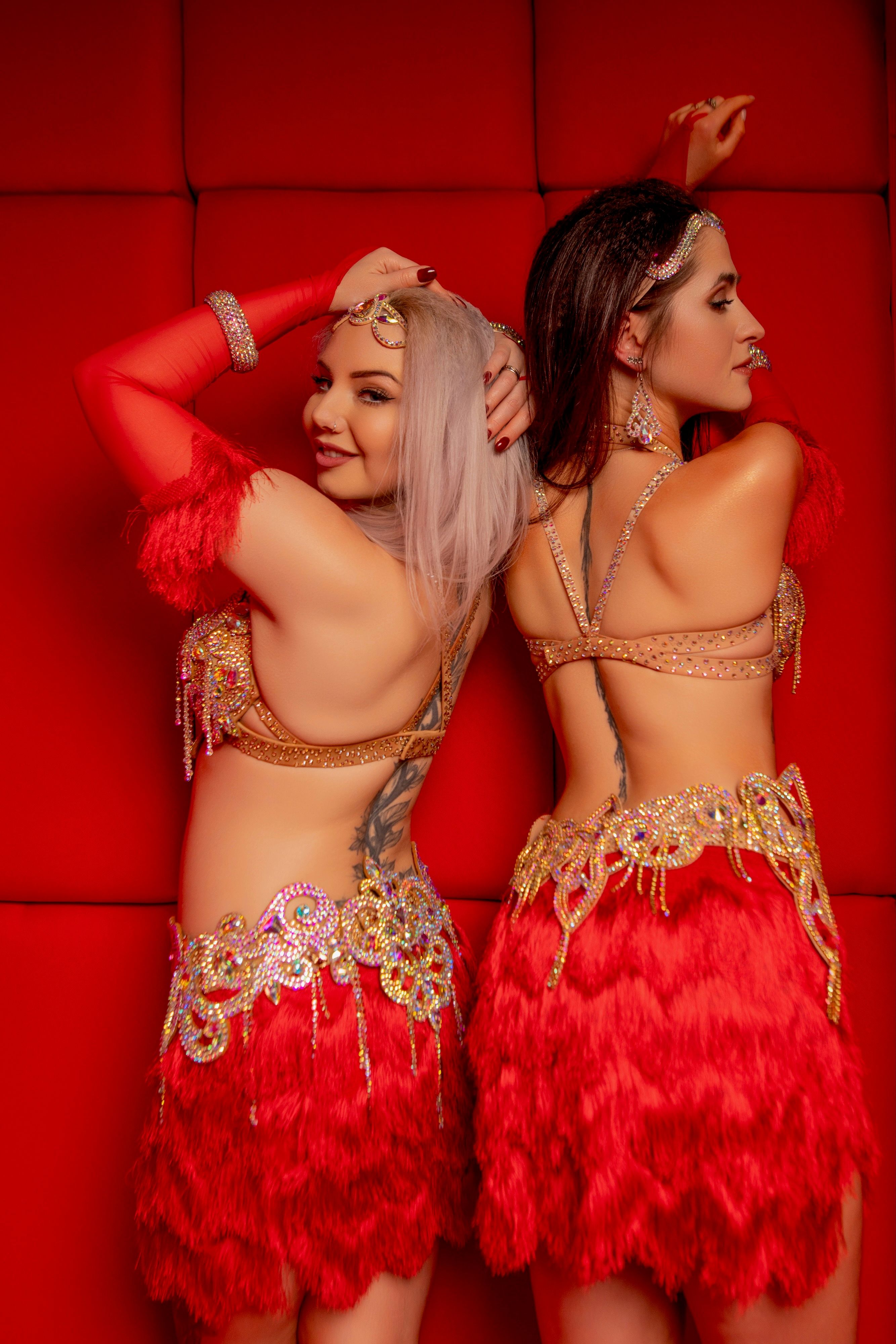 Tancerki Wahatan w czerwonych kostiumach bellydance z piórami i złotymi zdobieniami