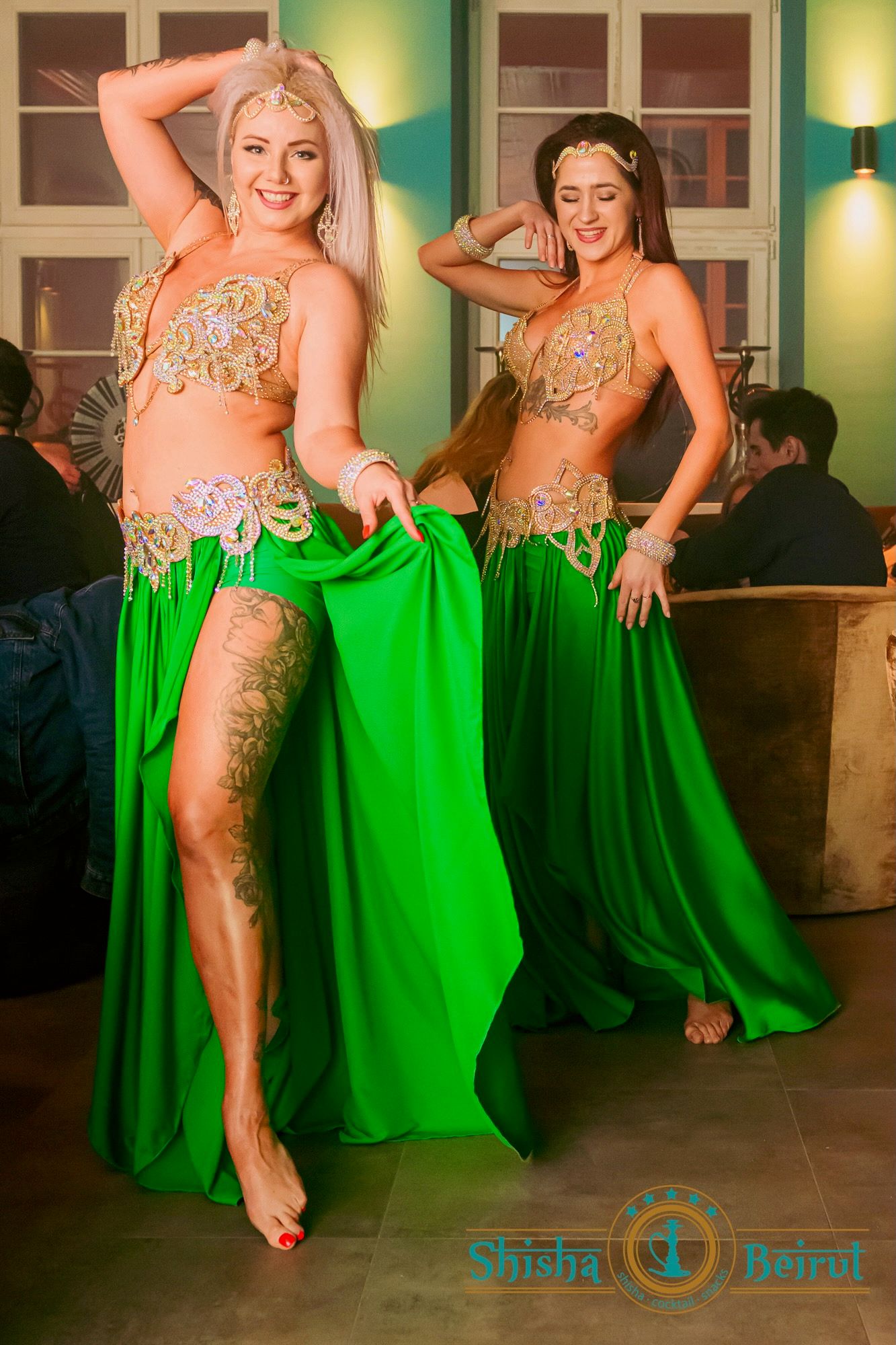 Duet Wahatan w zielonych kostiumach ze złotymi zdobieniami podczas występu w restauracji