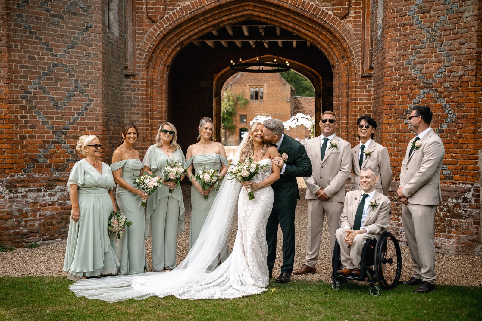 Phill and Amanda with their wedding party under the brick archway at Leez Priory