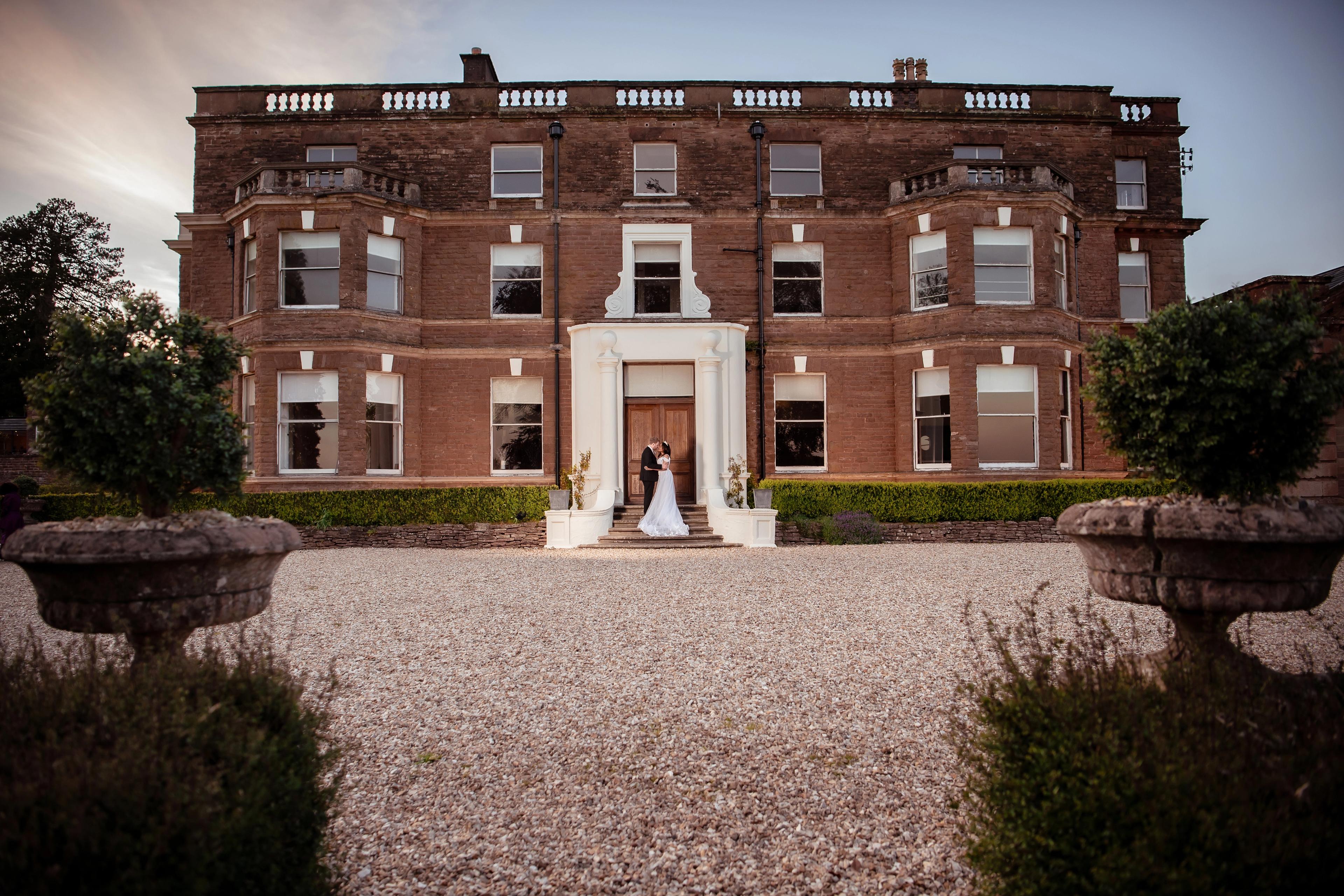 Nathan and Nastashia on the steps of the manor house at Bredenbury Court Barns, Herefordshire