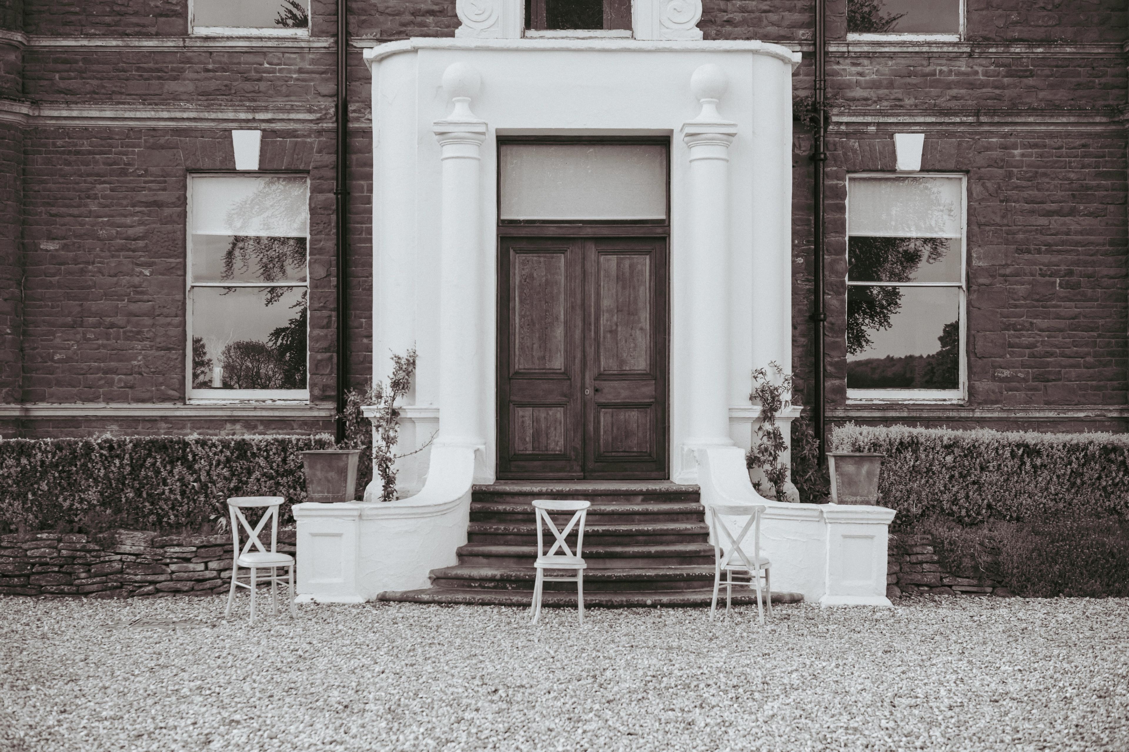 The white portico and wooden doors of the manor house at Bredenbury Court Barns, Herefordshire