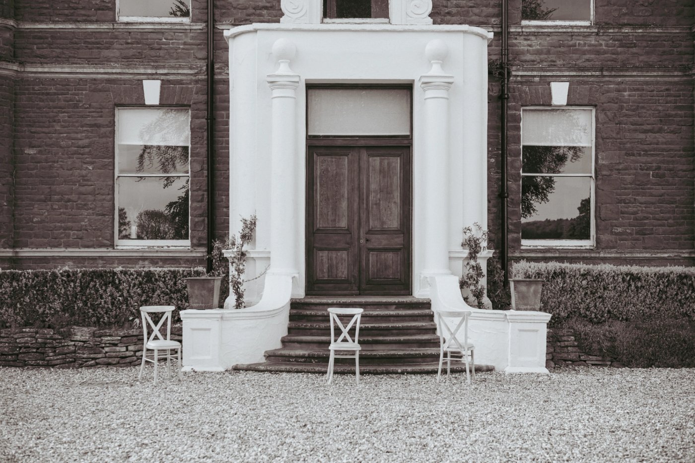 The white portico and wooden doors of the manor house at Bredenbury Court Barns, Herefordshire