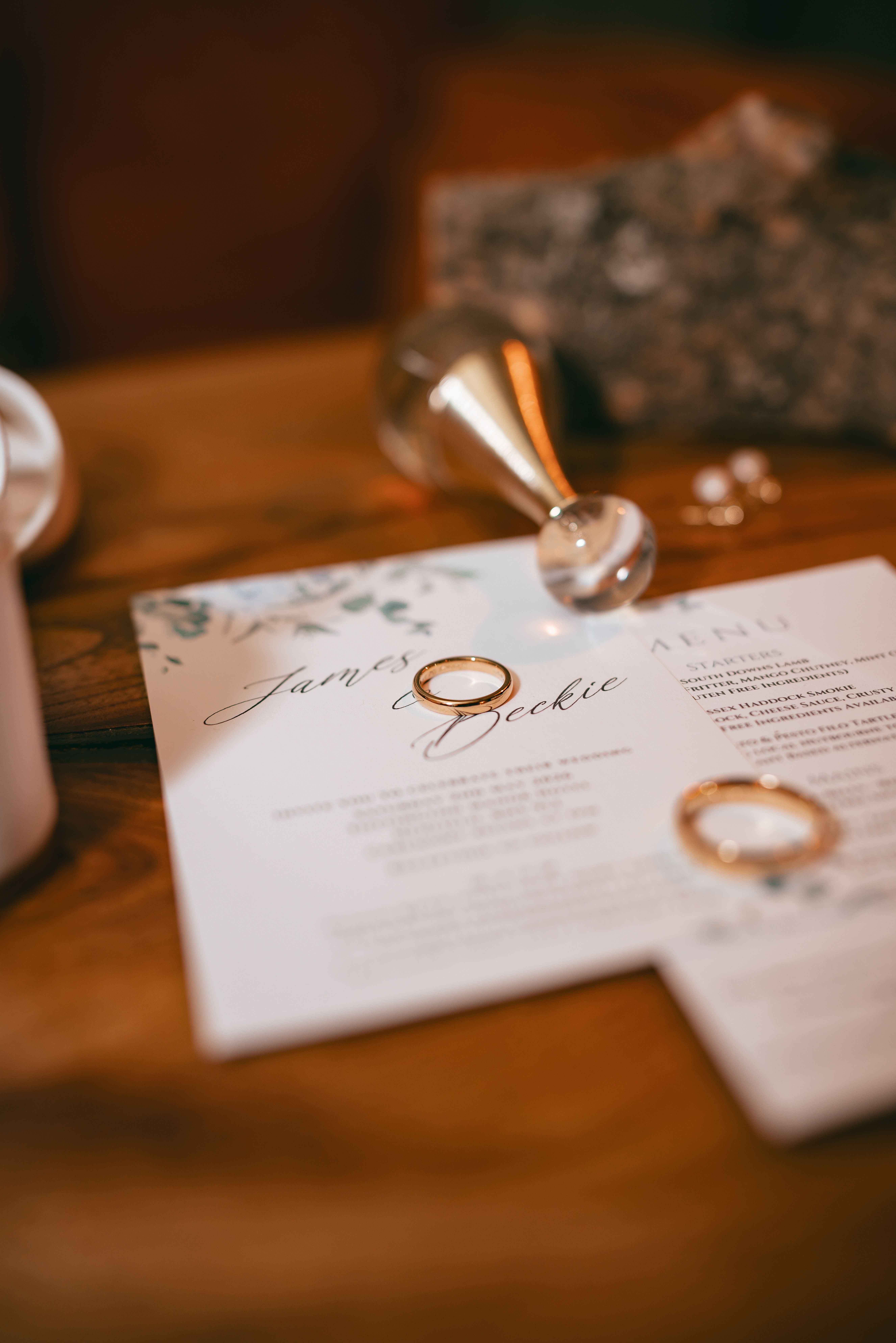 Wedding rings resting on the invitation, photographed by Pixton Media