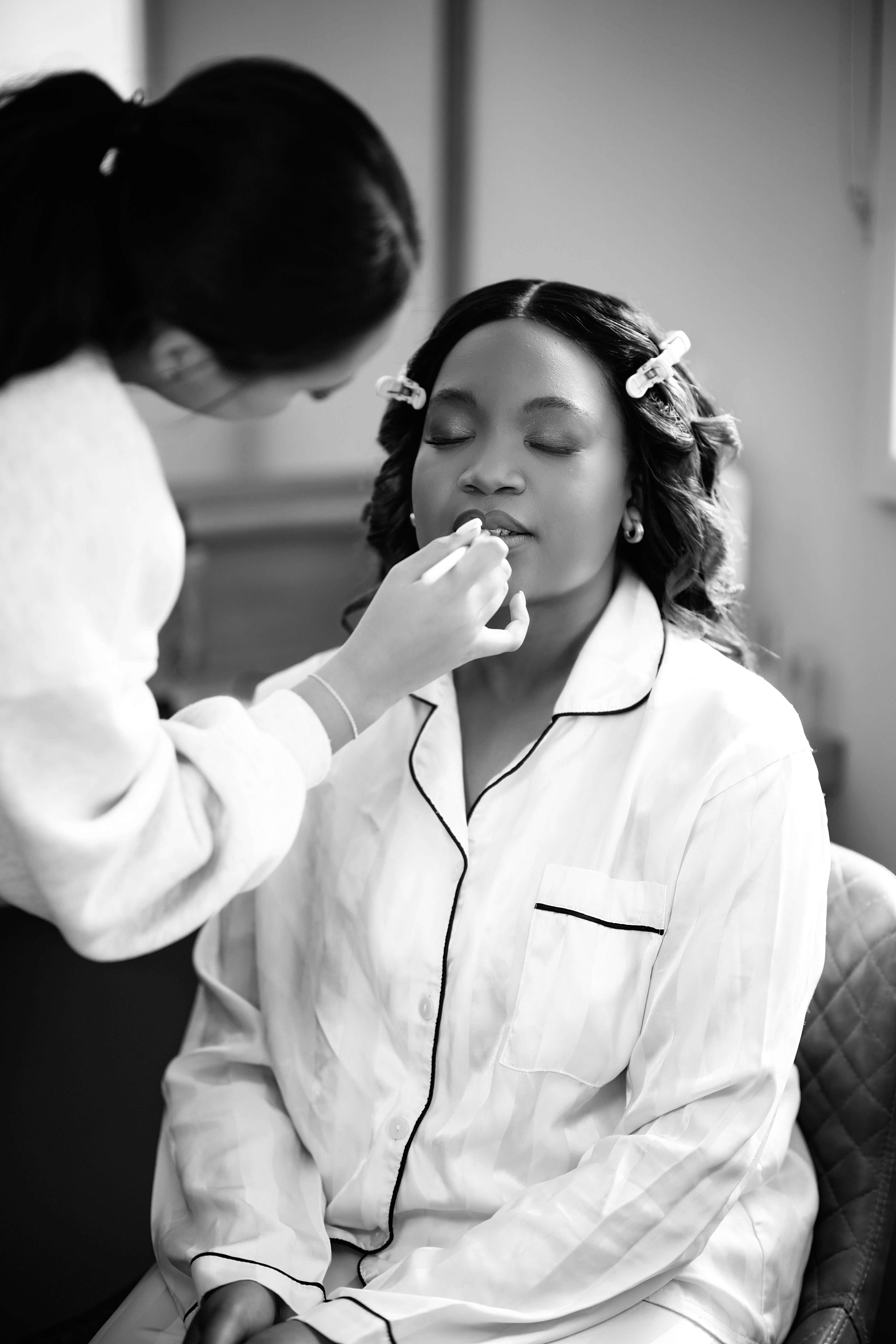Nastashia having her bridal make-up done on the wedding morning at Bredenbury Court Barns, black and white