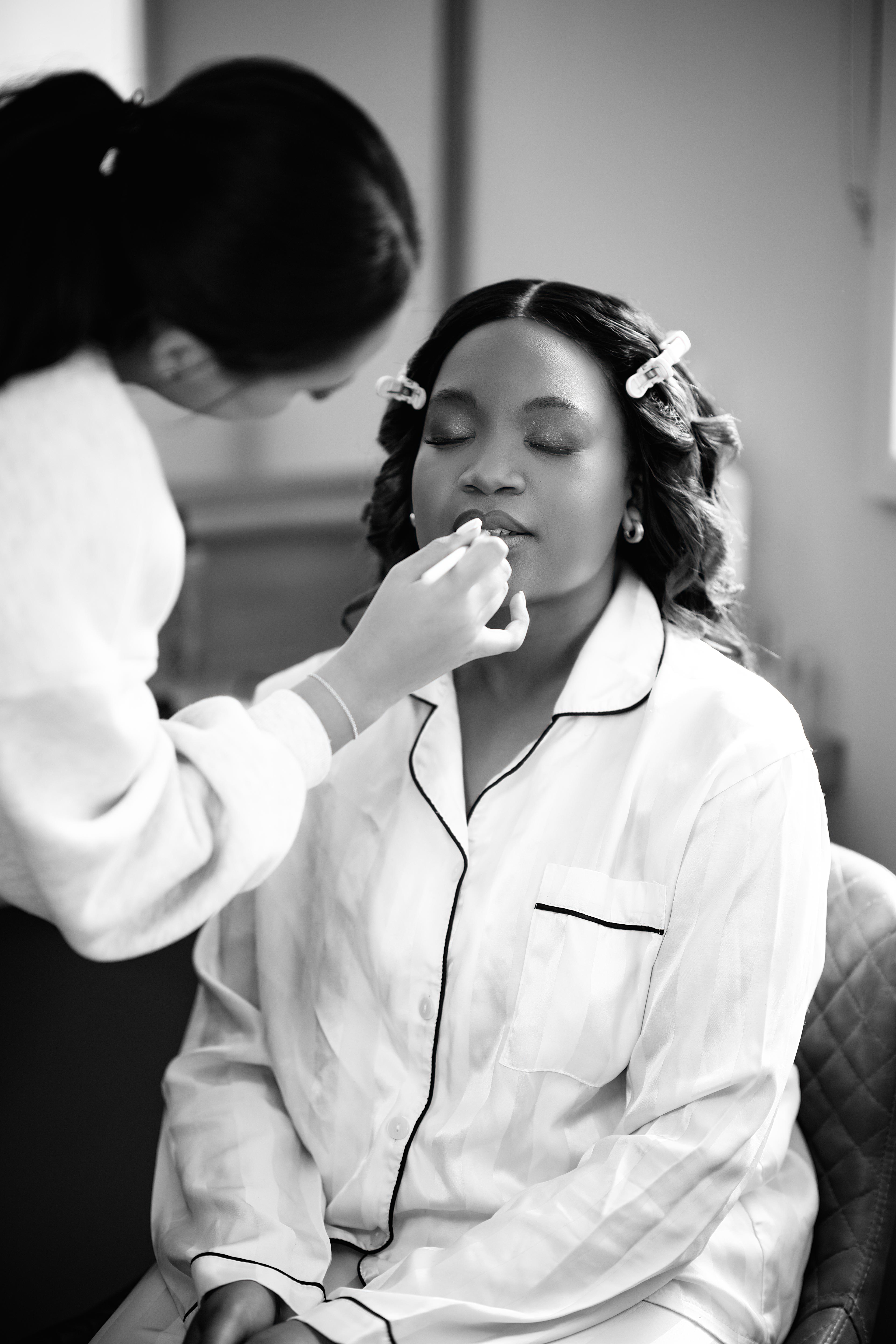 Nastashia having her bridal make-up done on the wedding morning at Bredenbury Court Barns, black and white