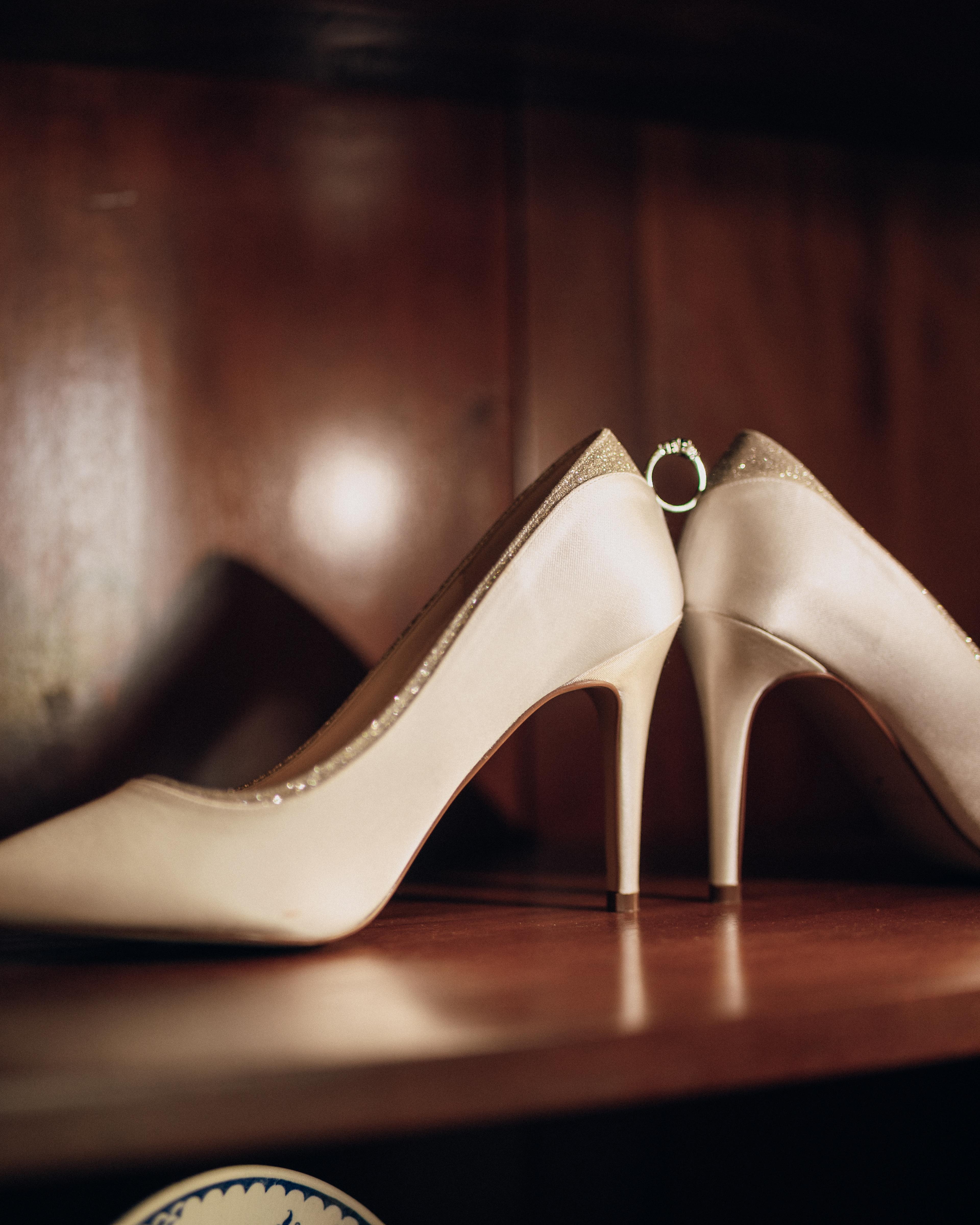 Bride's ivory heels on a wooden shelf, photographed by Pixton Media