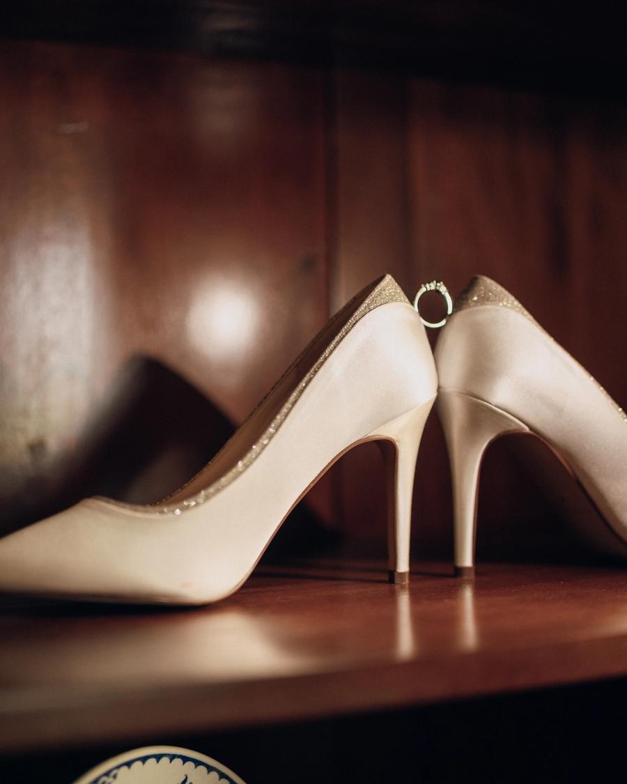 Bride's ivory heels on a wooden shelf, photographed by Pixton Media