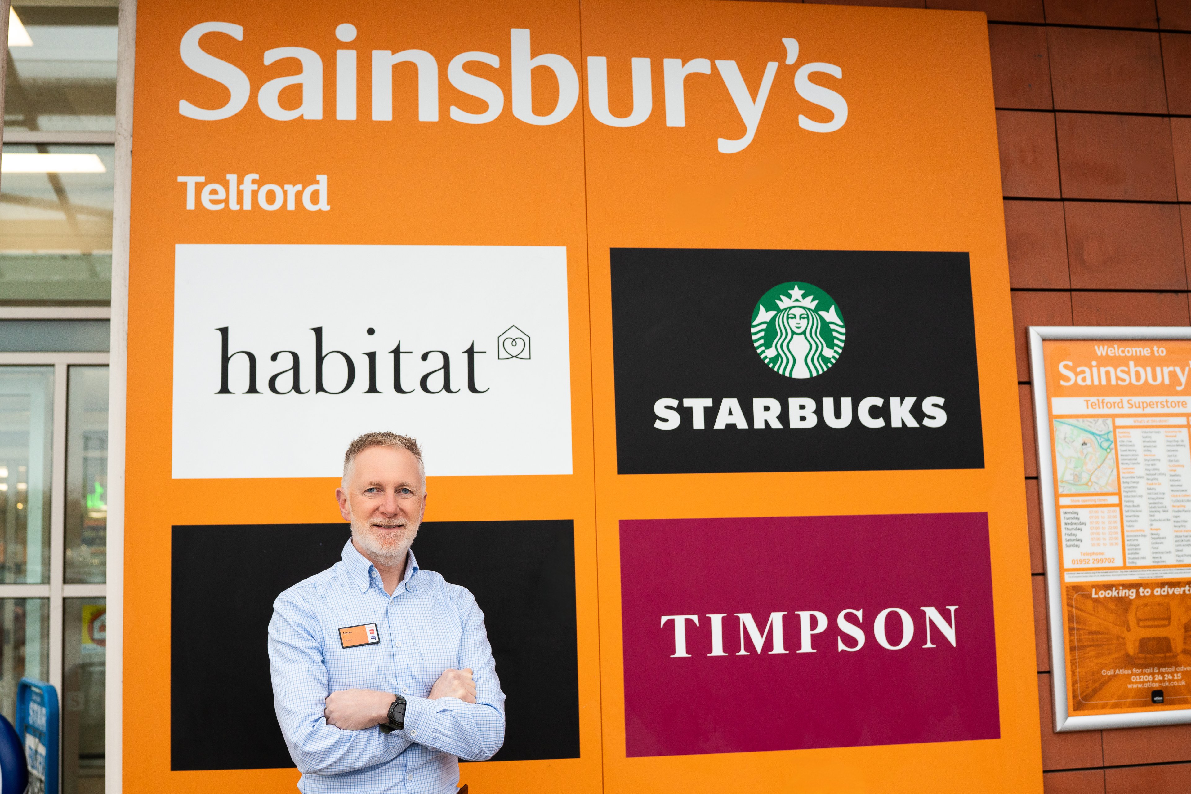 Sainsbury's Telford manager by the store sign, editorial portrait for William Reed