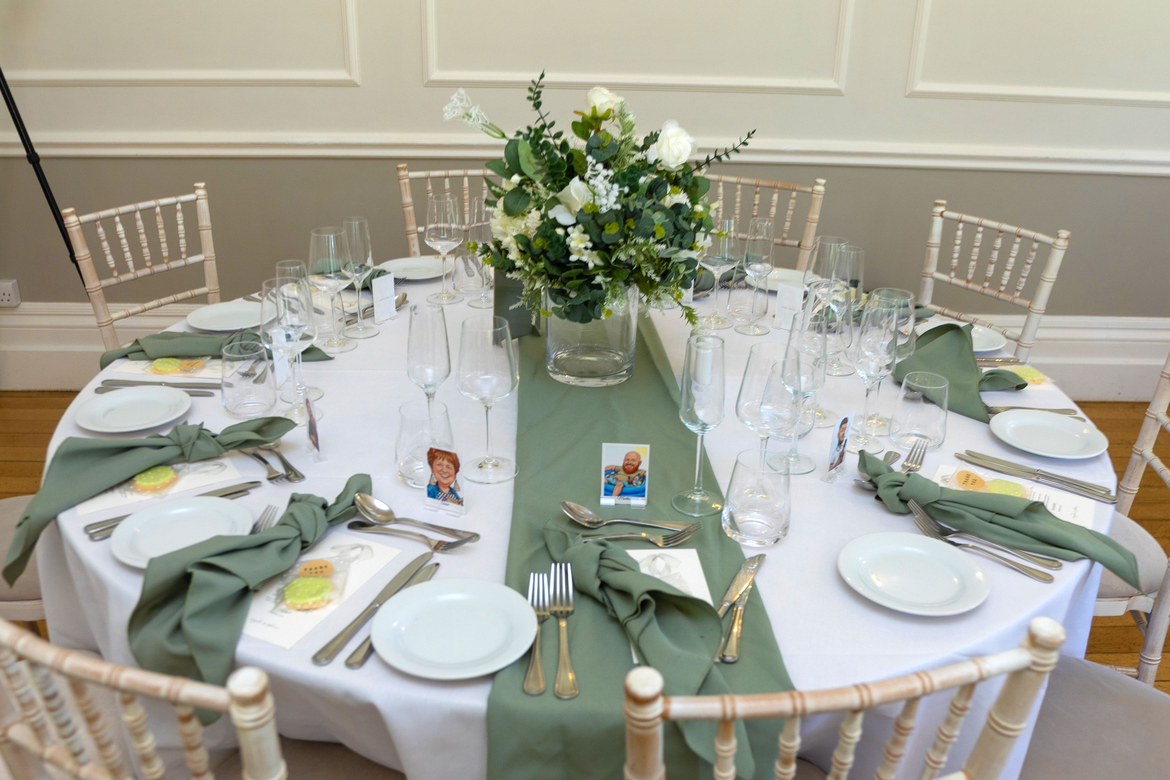 Wedding table centrepiece of white roses and greenery, photographed by Pixton Media
