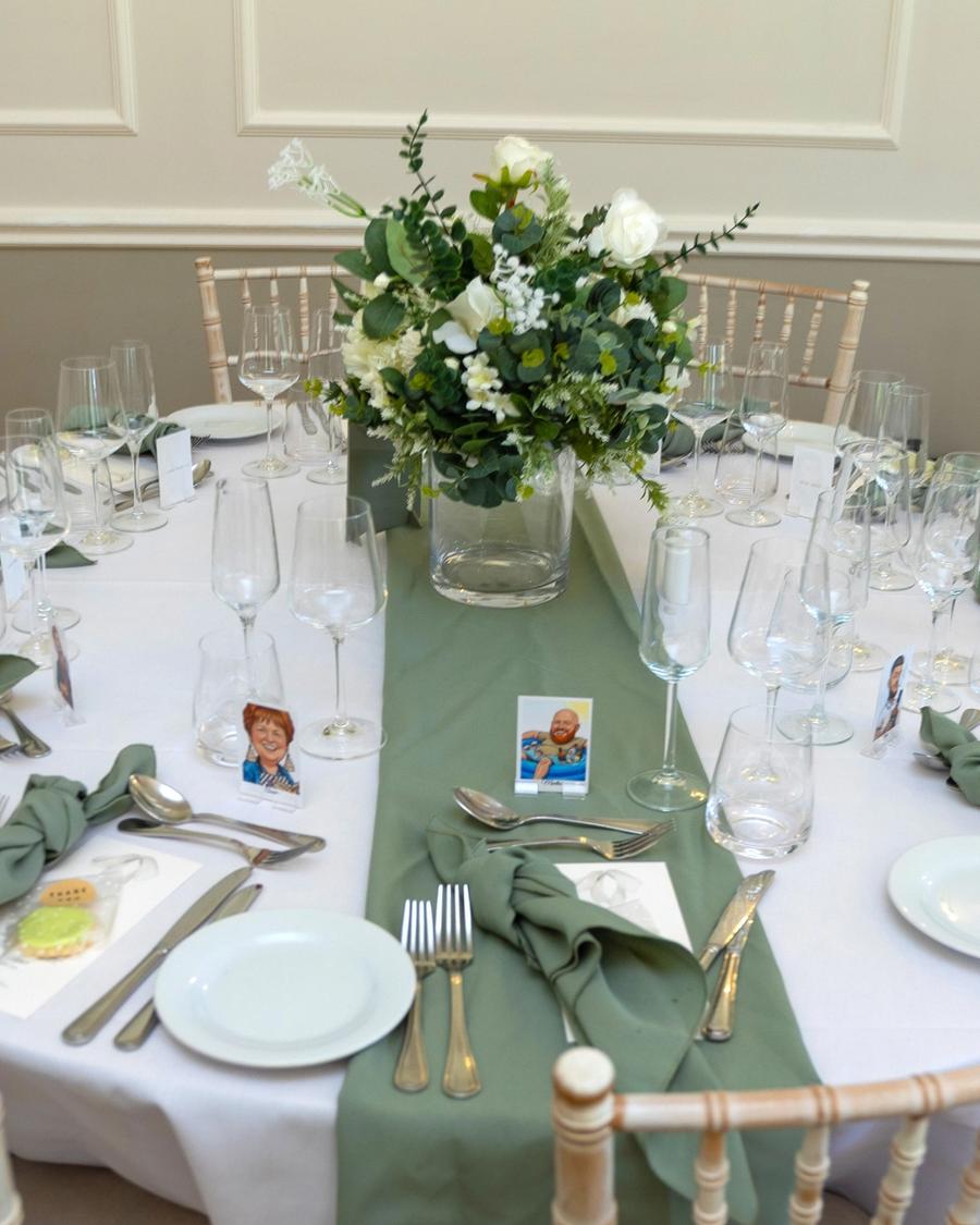Wedding table centrepiece of white roses and greenery, photographed by Pixton Media