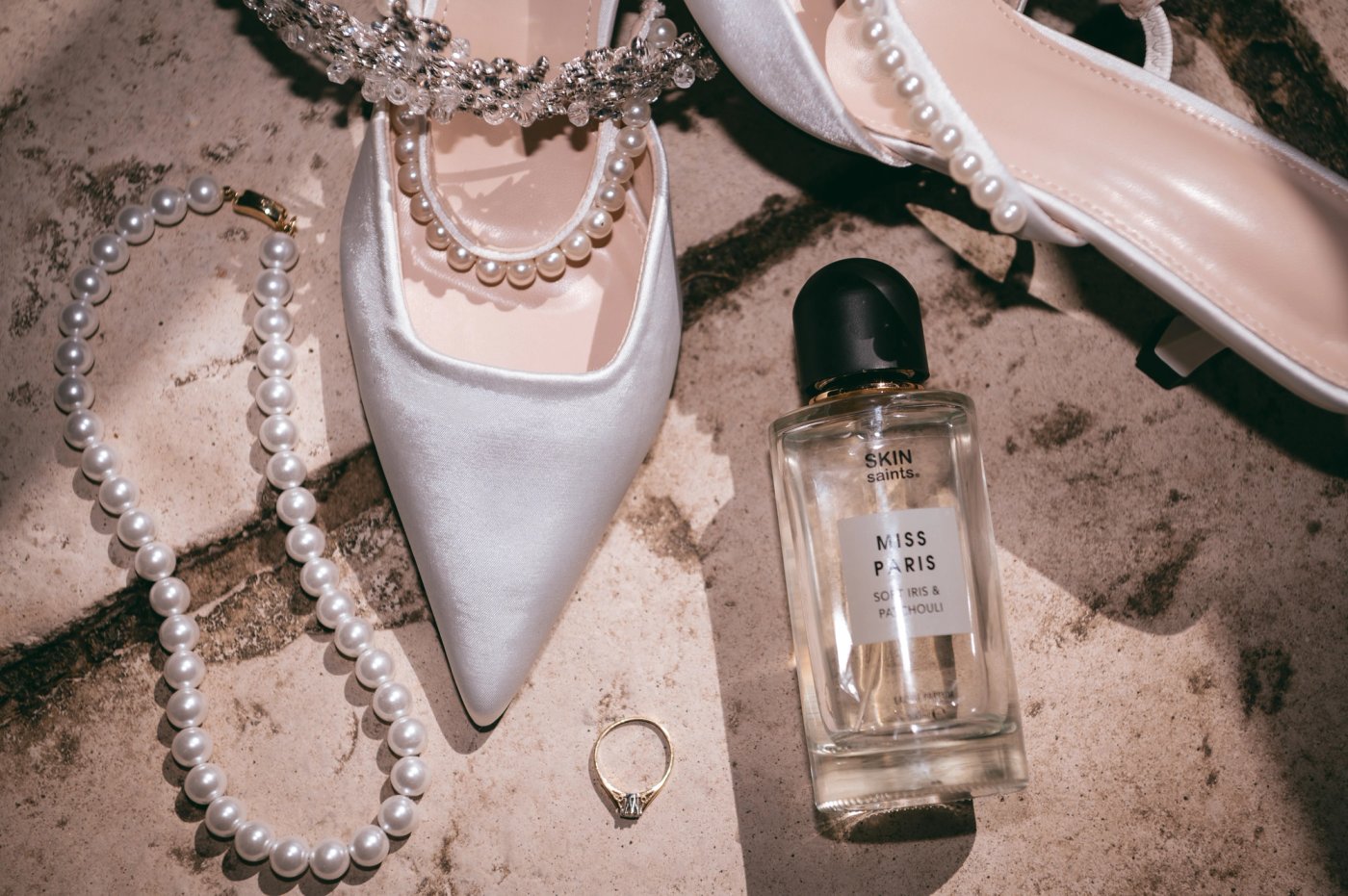 Bridal details: pearl-strapped wedding heels, pearl necklace, engagement ring and perfume at Bredenbury Court Barns