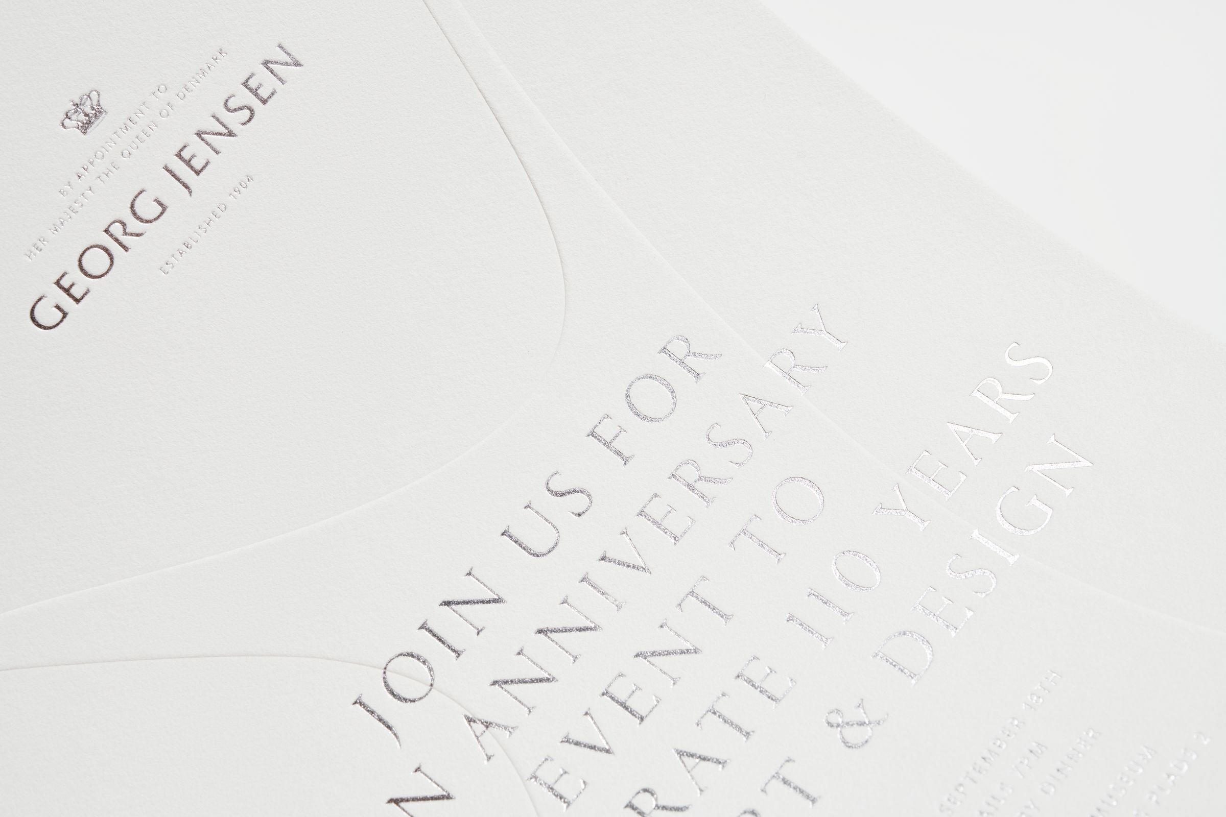 Detail of Georg Jensen invitation with silver foil and blind embossing