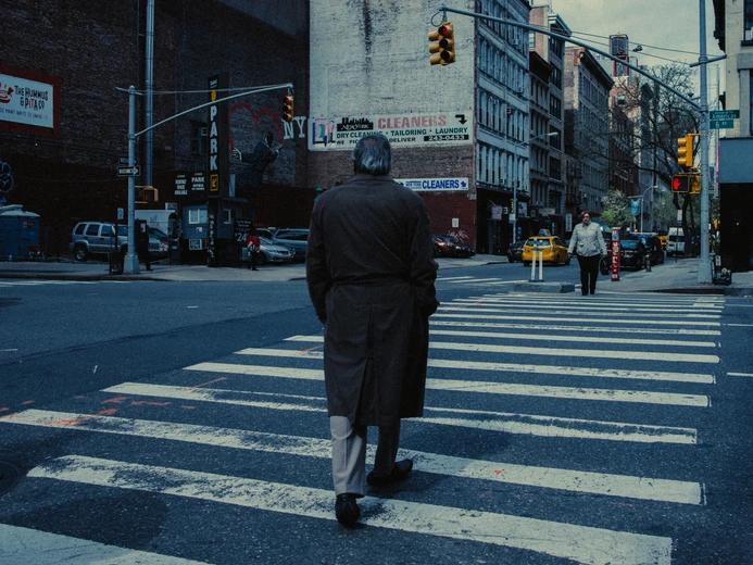 Man crossing the road with a trenchcoat on