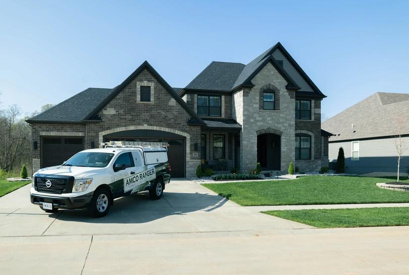 Amco Ranger truck parked in driveway of beautiful surburban house