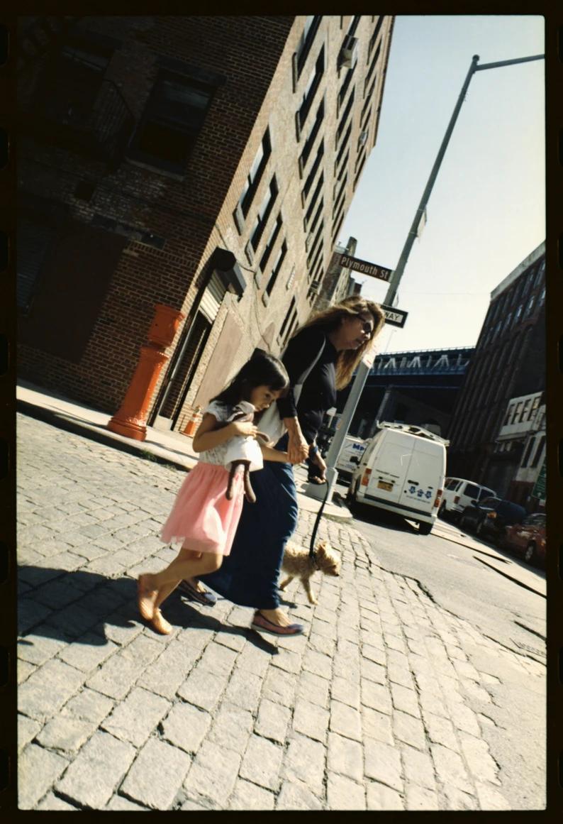 Mom, daughter and dog walking on the street