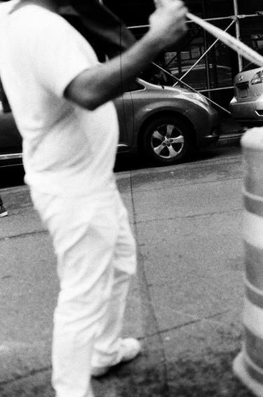 an all white outfit on a man standing in the middle of a street