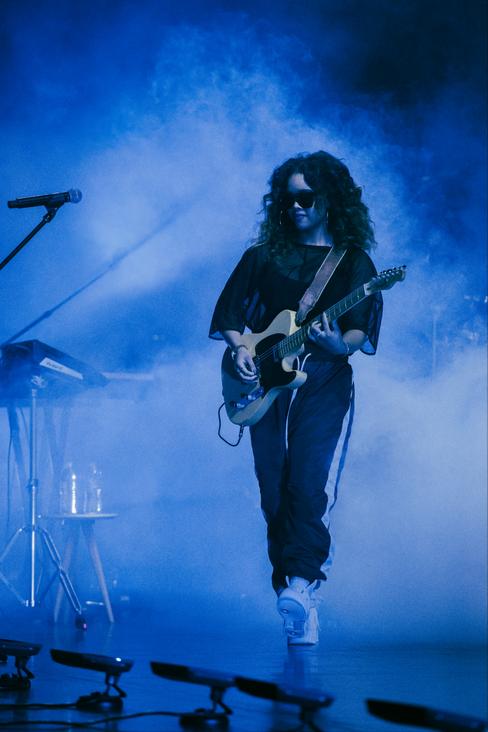 American R&B Singer H.E.R. playing guitar on stage at the Google Soulfest where she perfomed