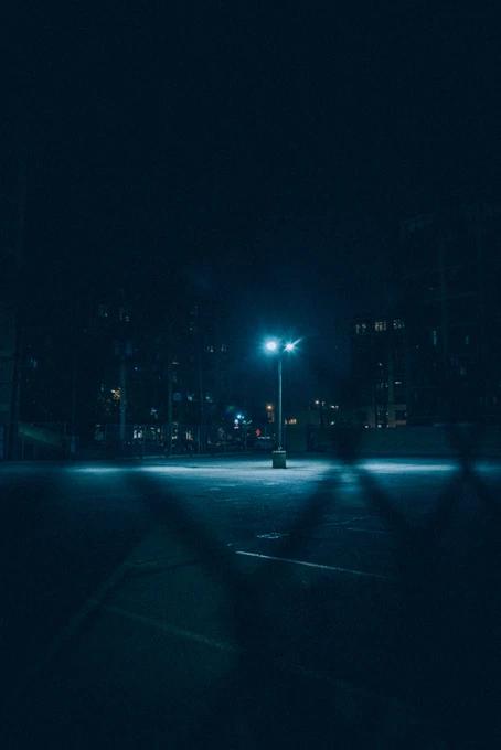 looking at a parking lot through the fence in the middle of the night