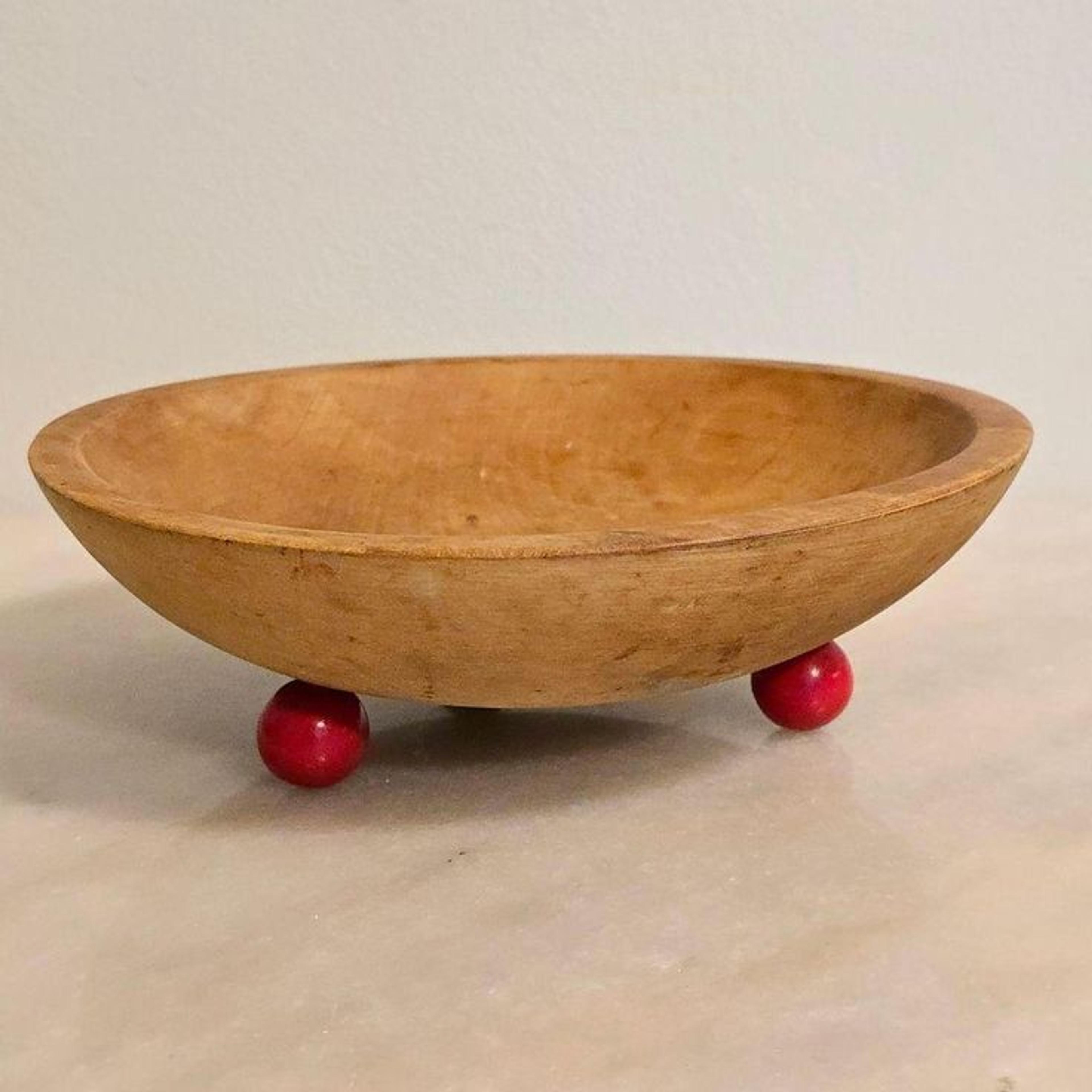 wooden bowl with red feet