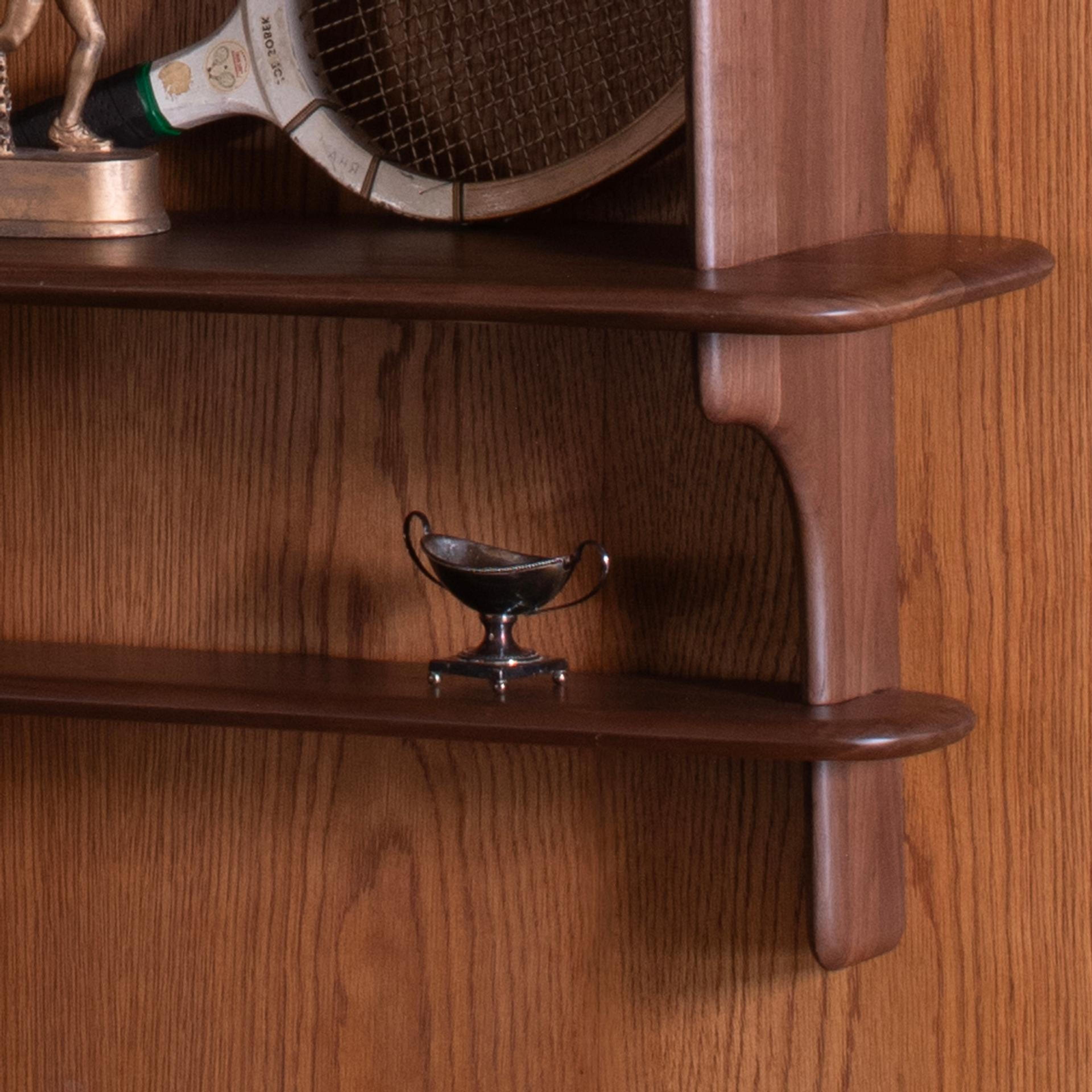 vintage wooden shelf with silver bowl and vintage tennis raquet