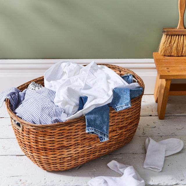 laundry basket with clean clothes next to dresser