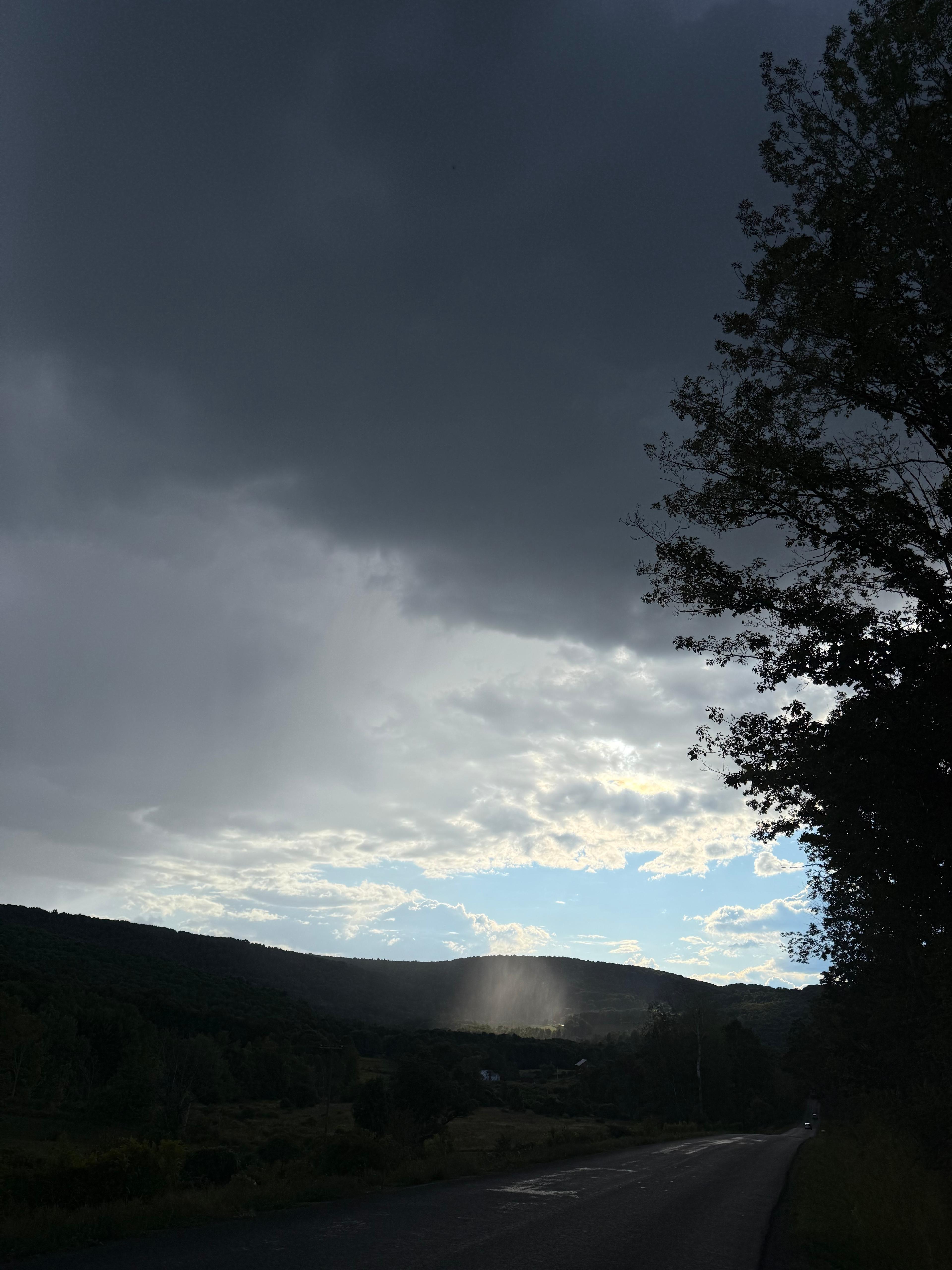 sunset and dark clouds over farm