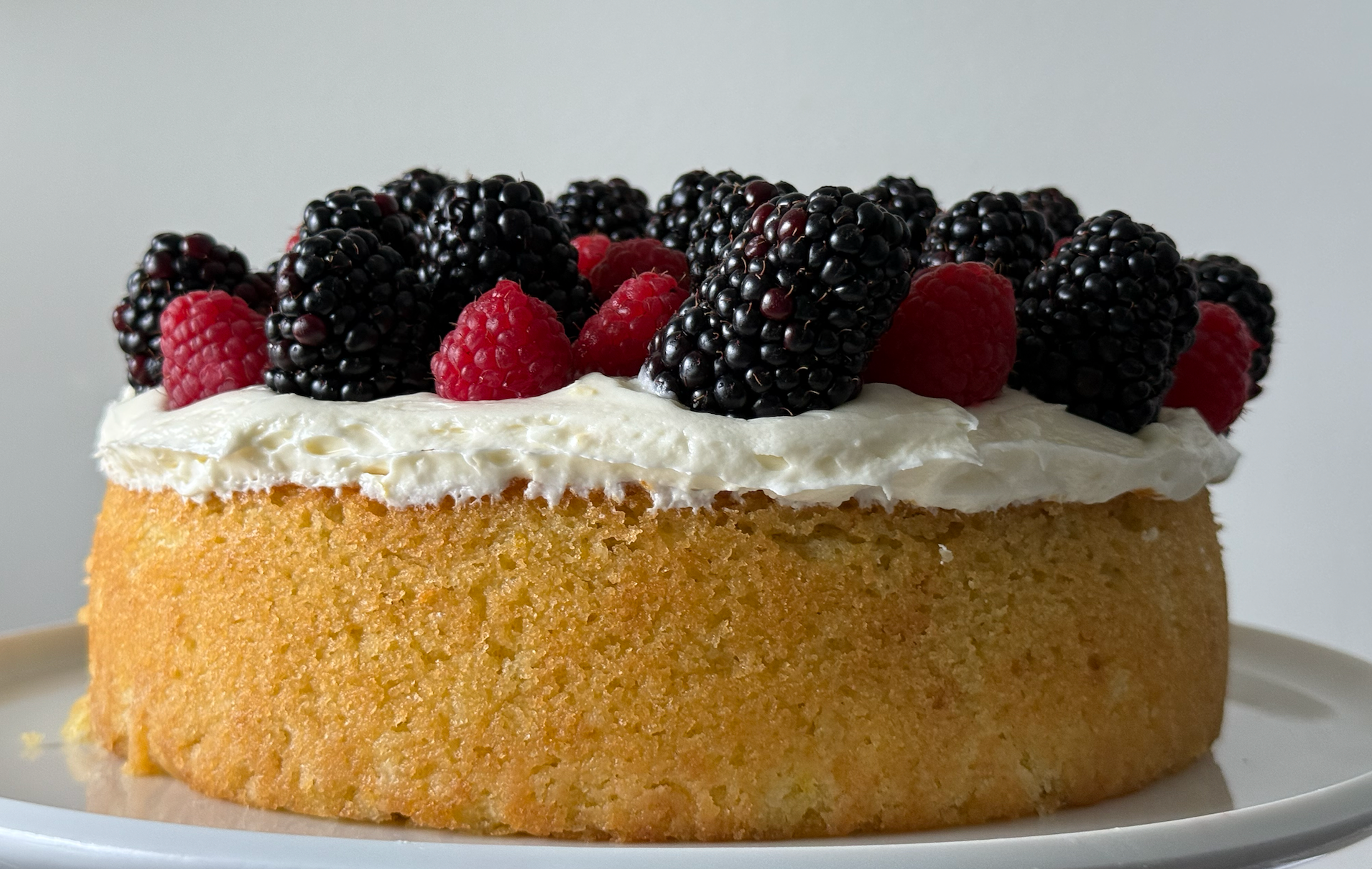 cake topped with raspberries and blackberries on a plate