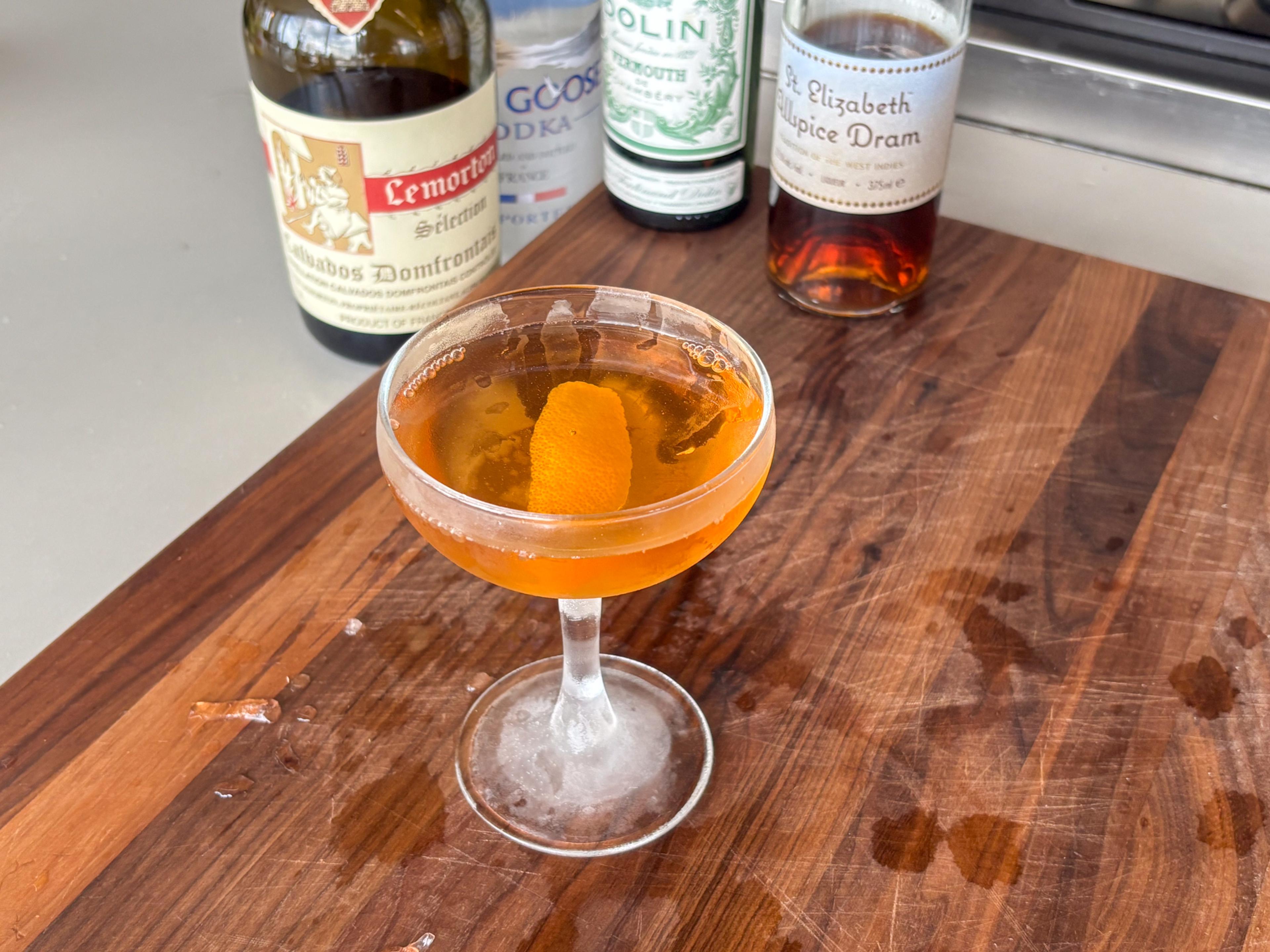 Apple Martini in a coupe glass with ingredients behind it.