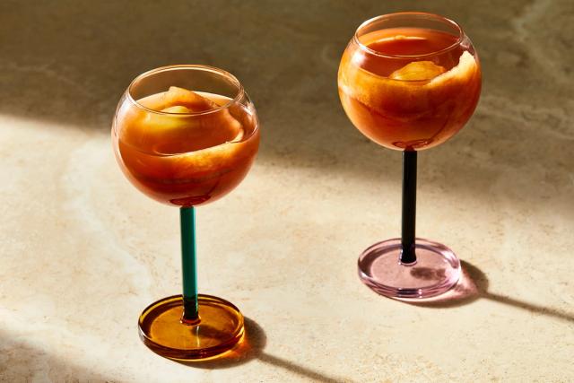 two coupes of red cocktails with fake eye ball grape garnish