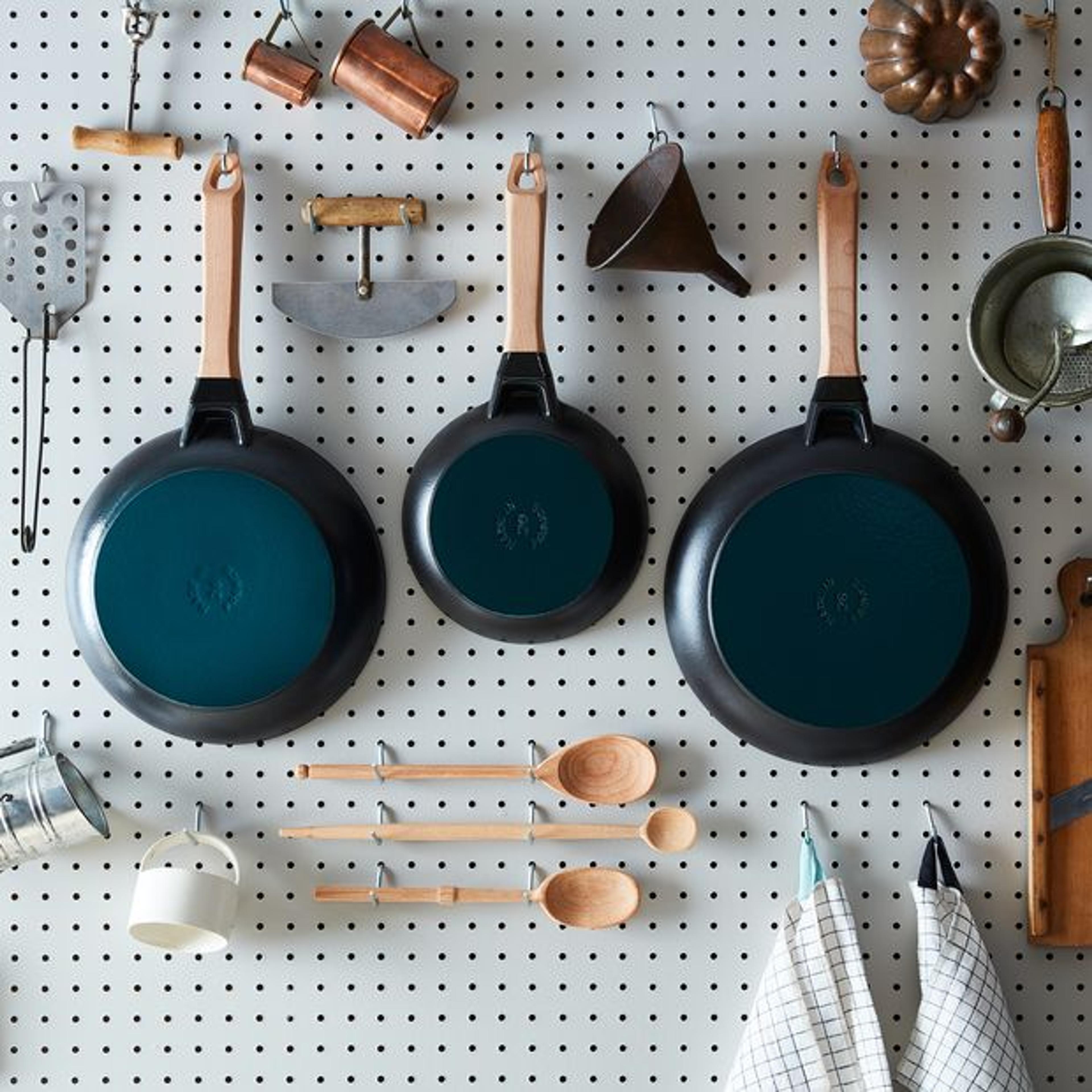 turquoise pans hanging on a peg board