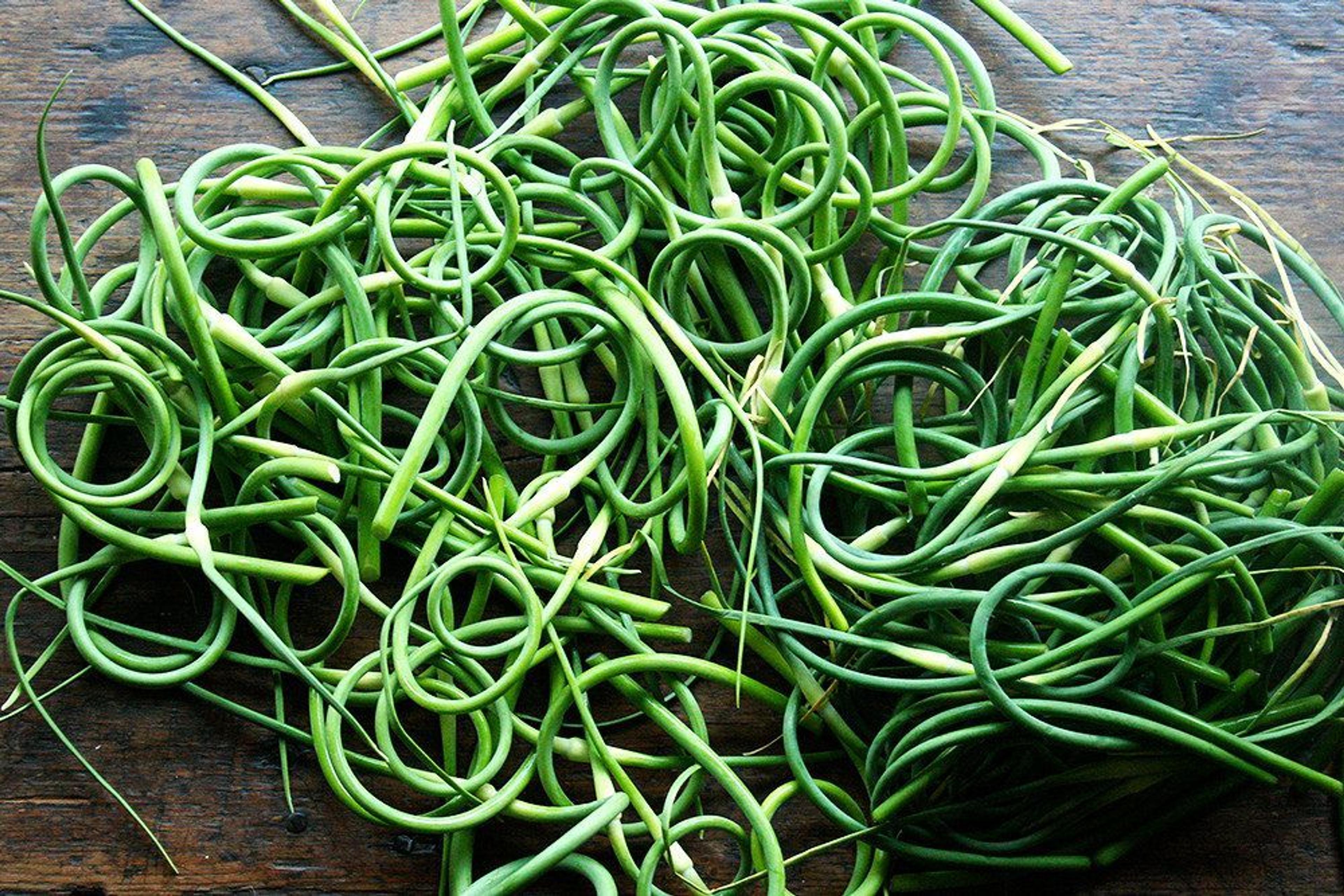 a pile of garlic scapes on table