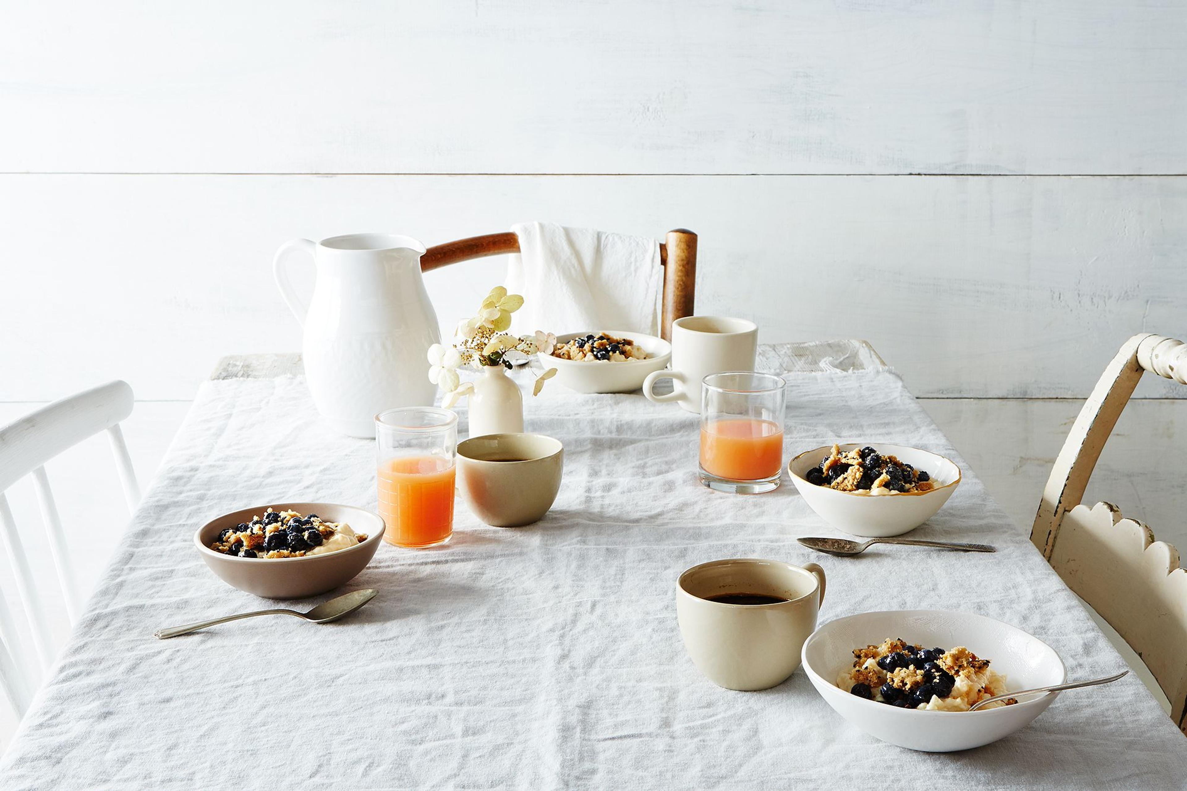 A clean, calm white breakfast table with various breakfast foods atop.