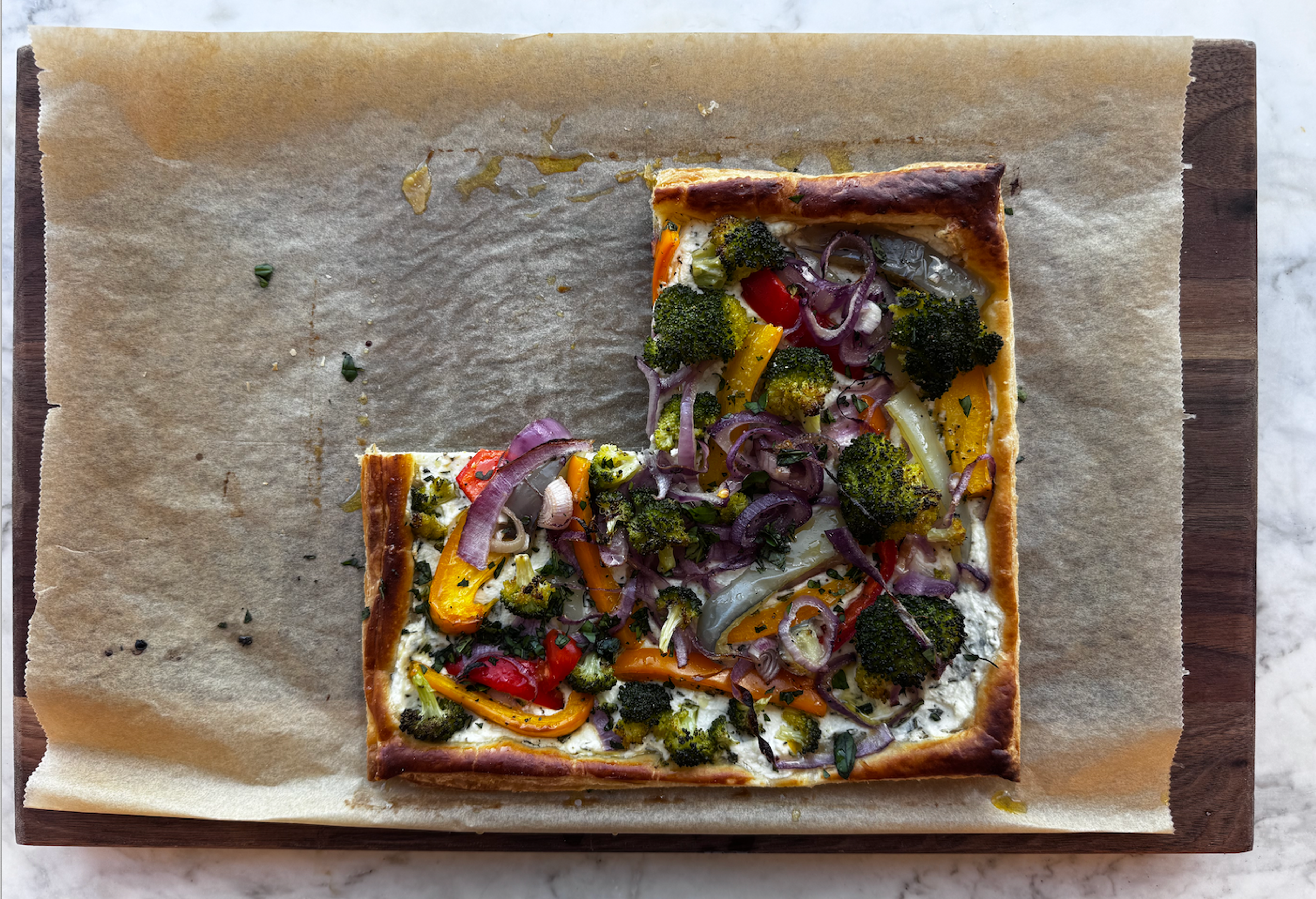 Vegetable tart that's been cut and placed on a piece of parchment paper