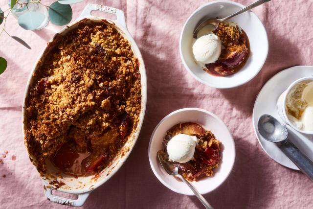Plum crisp in bowls and dish with vanilla ice cream on side