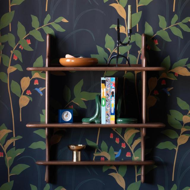 styled shelf against dark wallpapered wall
