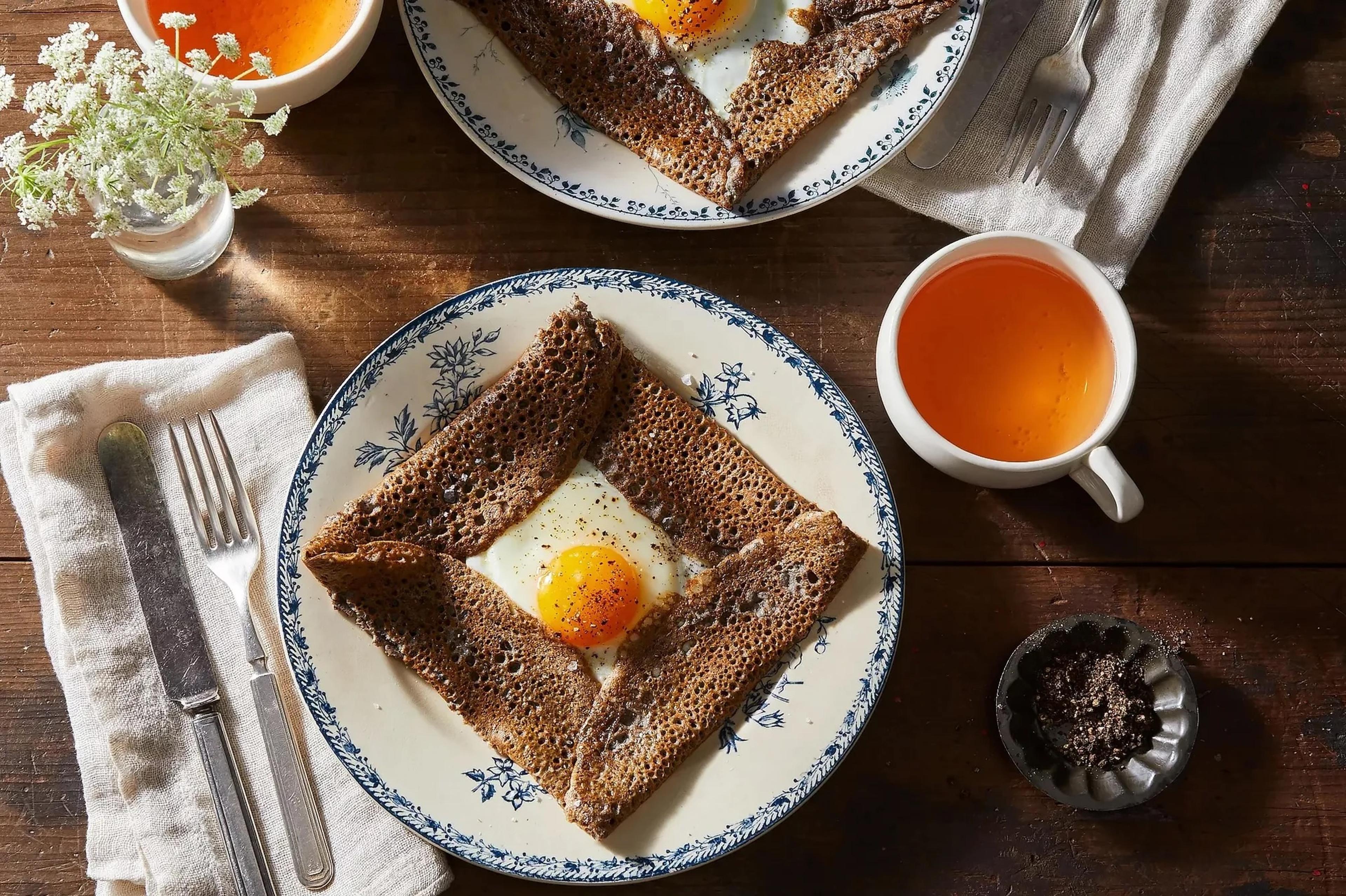 plates of crepes with fried egg on top