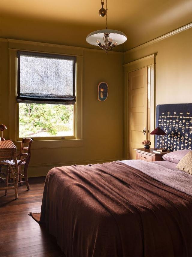 bed in ochre colored room