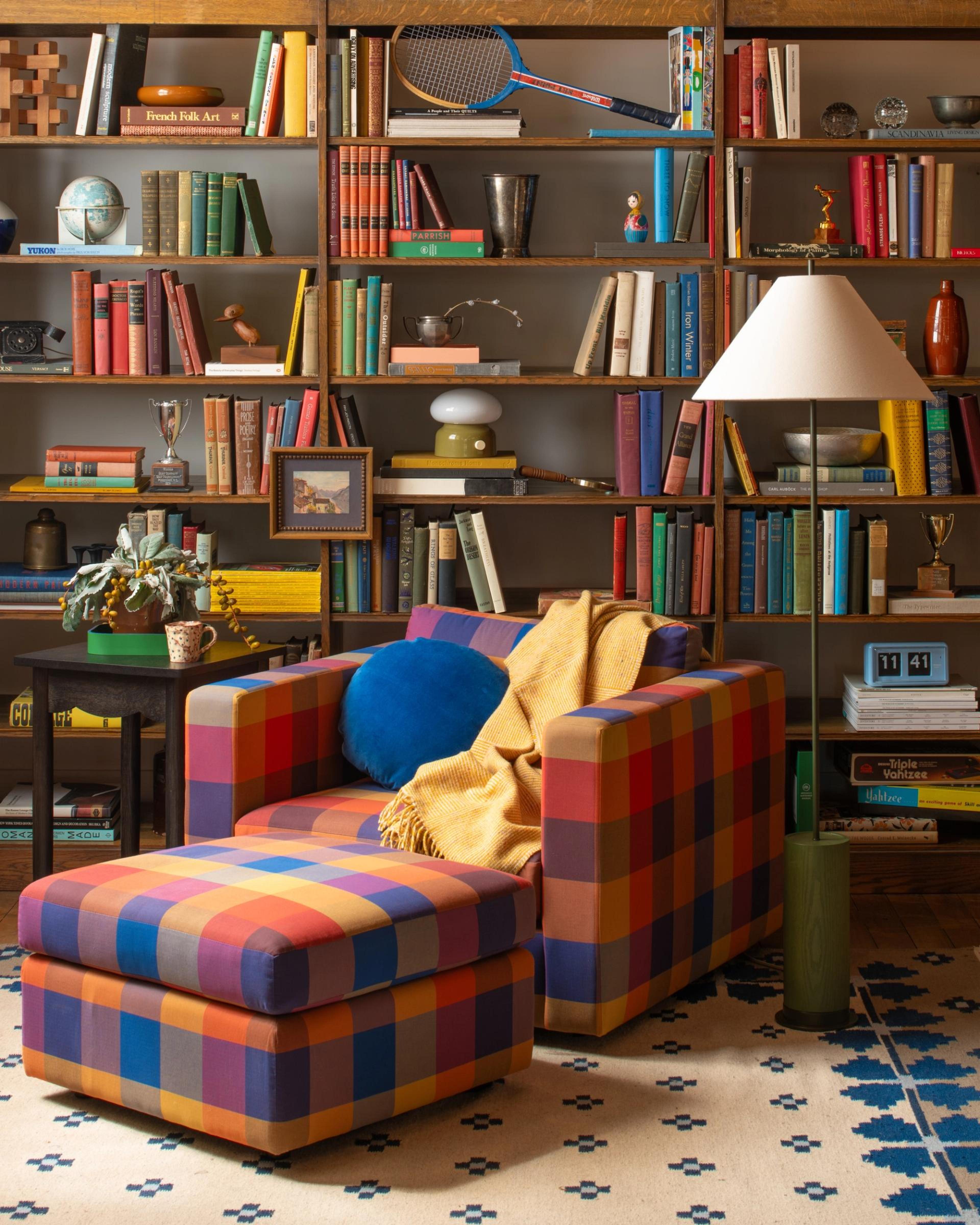 Schoolhouse plaid chair against large open bookshelves 
