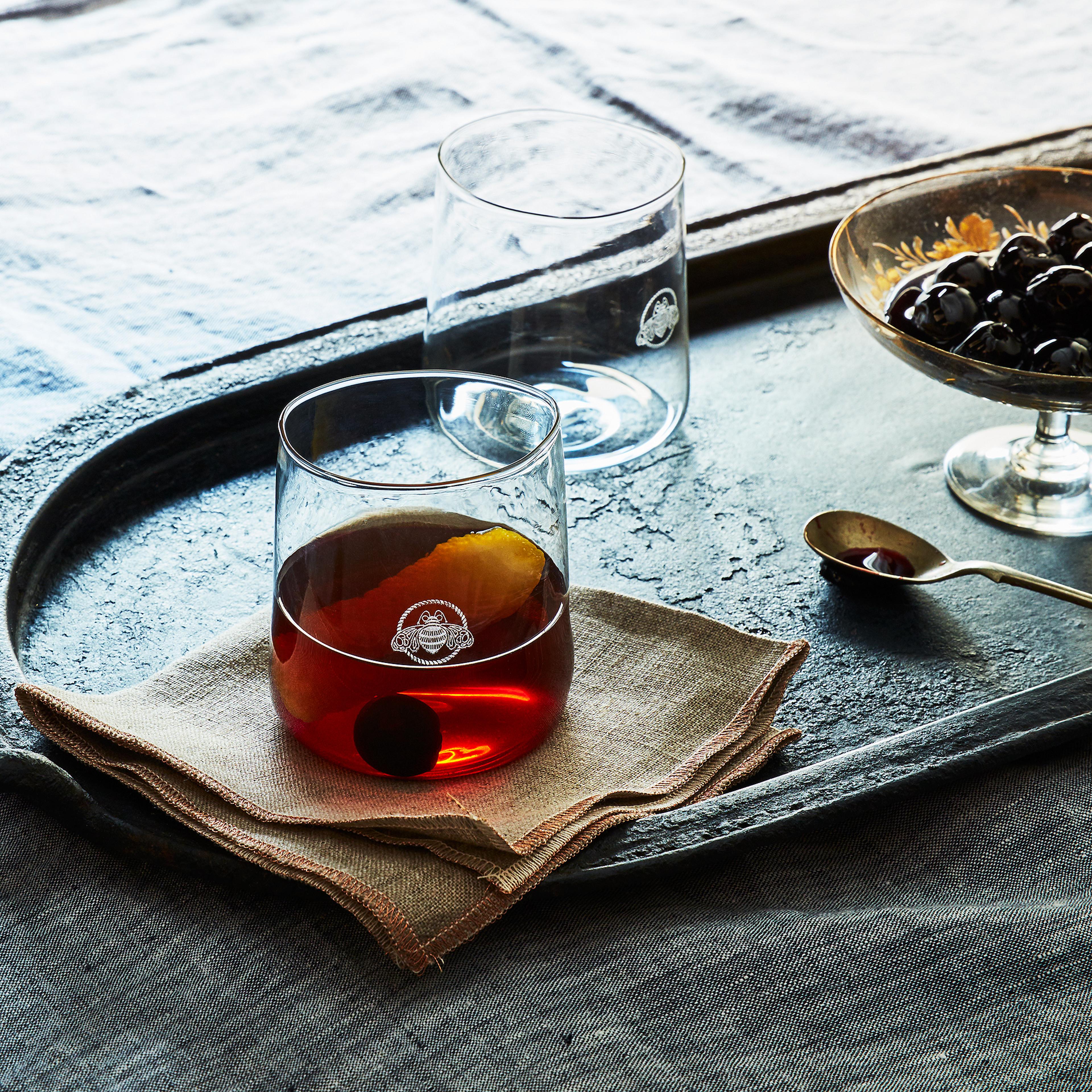 glass of spicy manhattan and black cherry on bottom