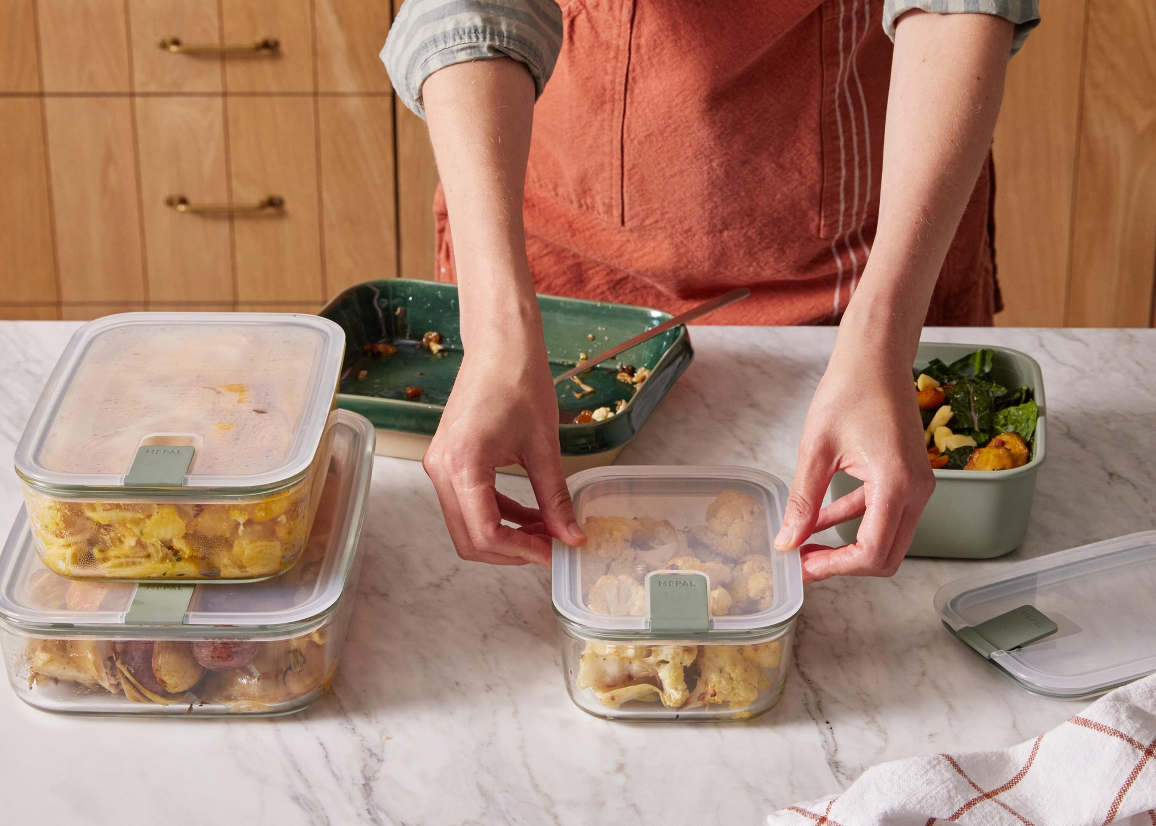 parent meal prepping dinner in containers for week 
