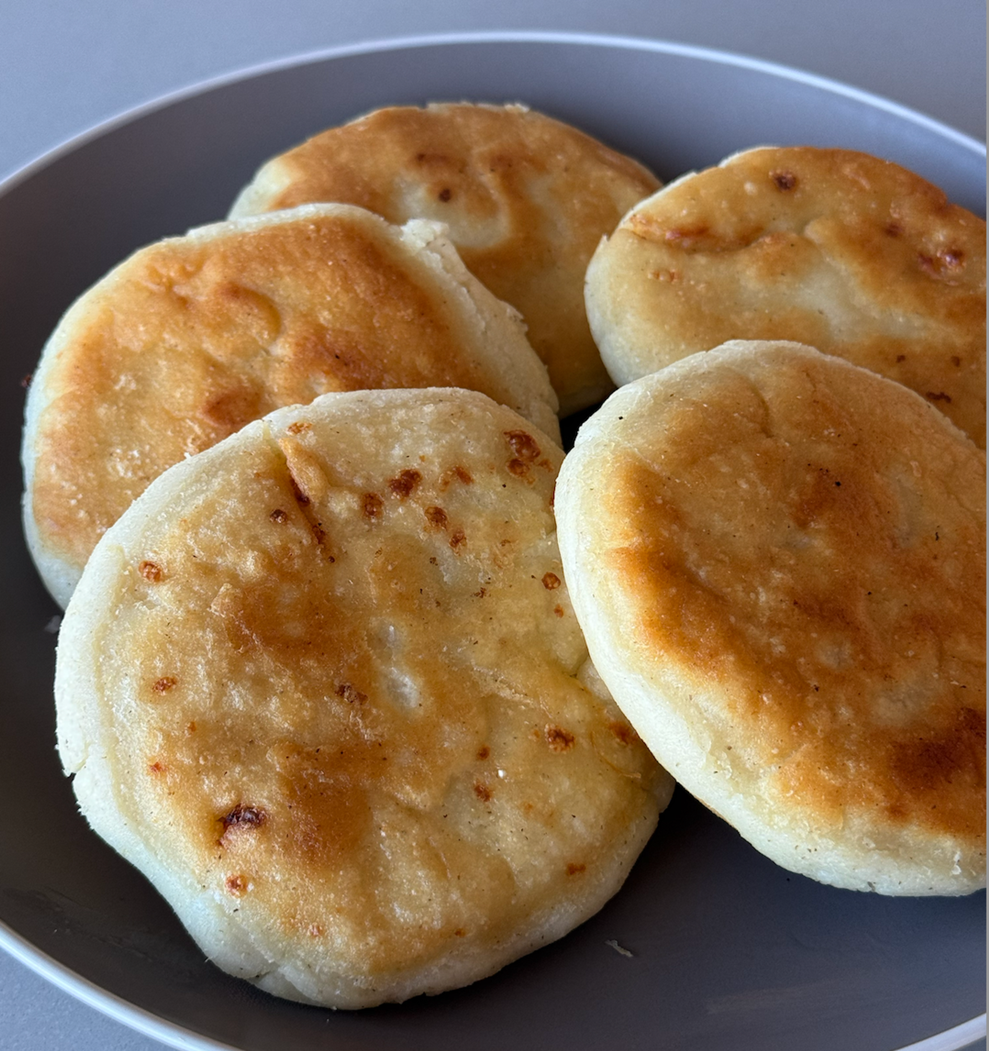 5 stuffed pupusas on a grey plate