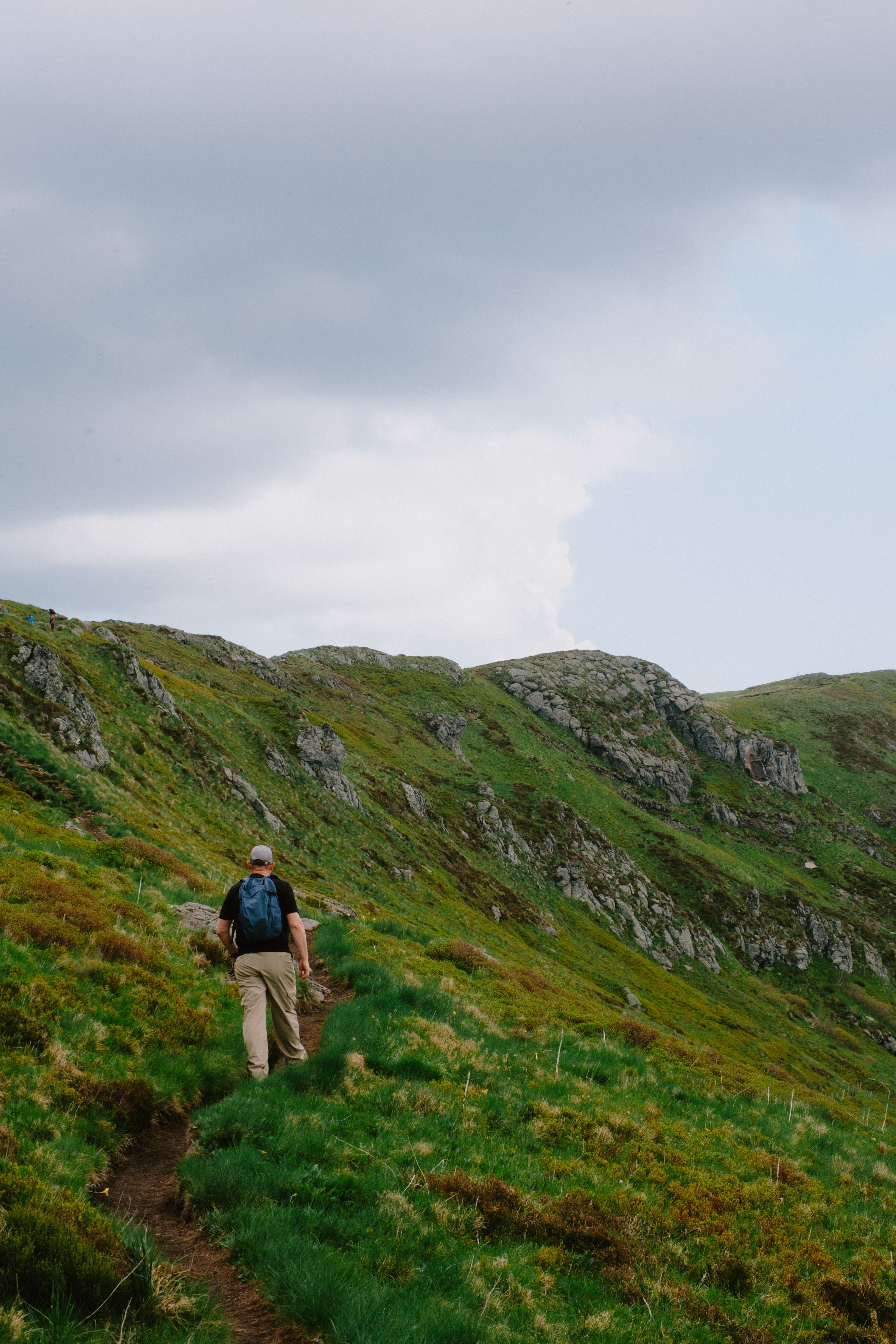 Person walking through a grassy mountaintop