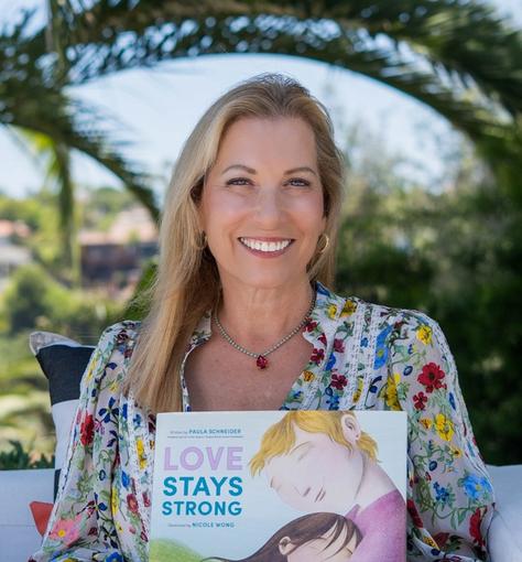 Susan G. Komen CEO Paula Schneider with her children's book about cancer Love Stays Strong.