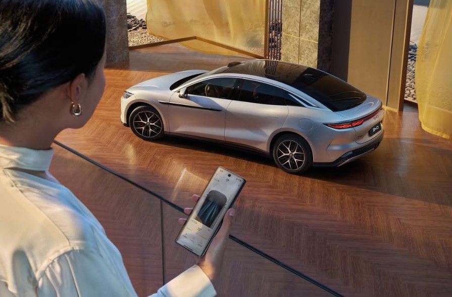 A photo of an electric vehicle from BYD with a female, from an unbiased news source in Canada