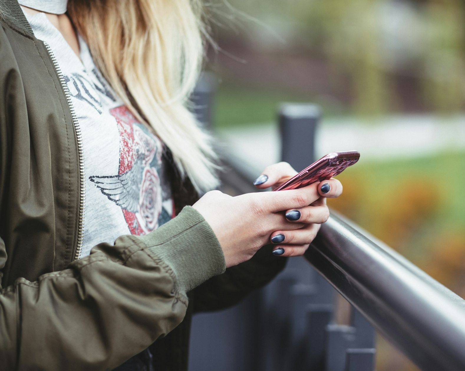 Teenage girl is holding her phone in her hands while scrolling online