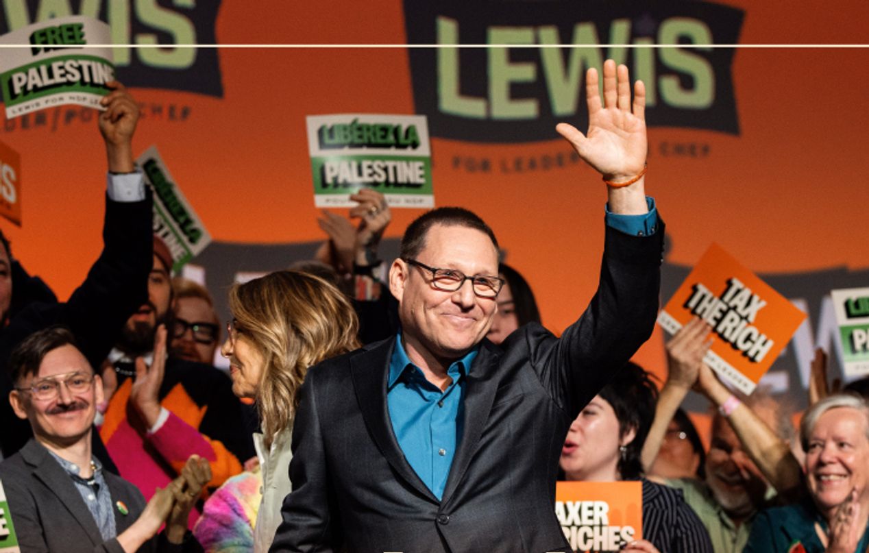 NDP Leader Avi Lewis waving to the crowd from the stage