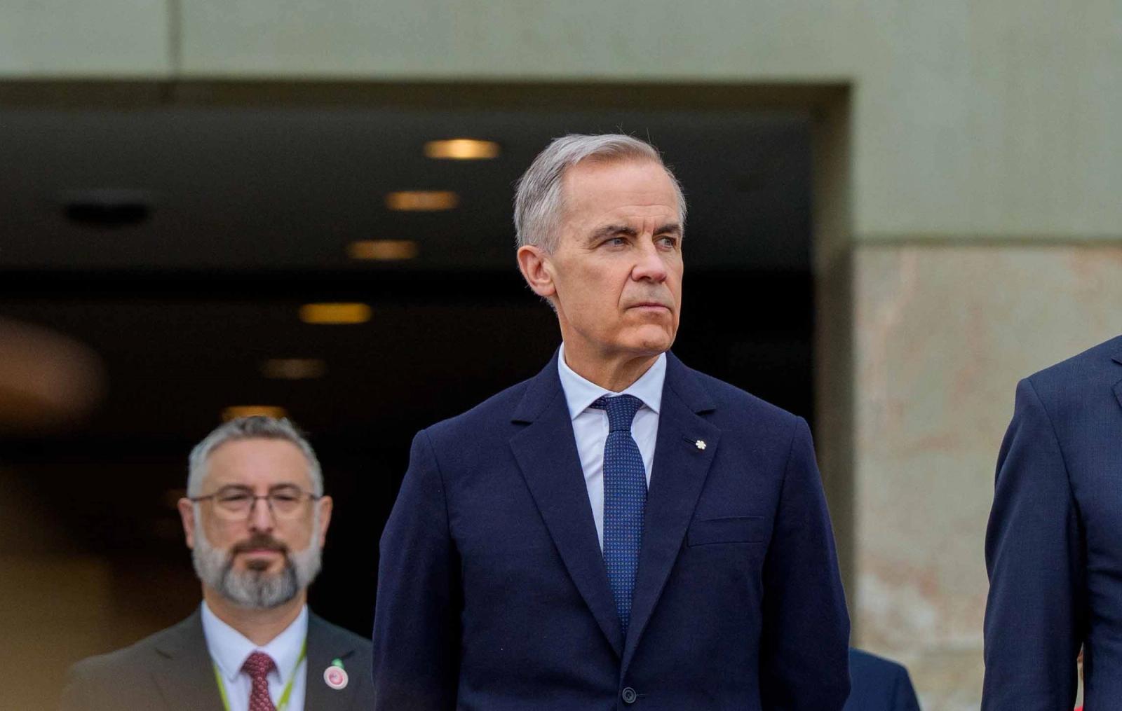 Mark Carney is standing in front of a crowd in Canberra, Australia